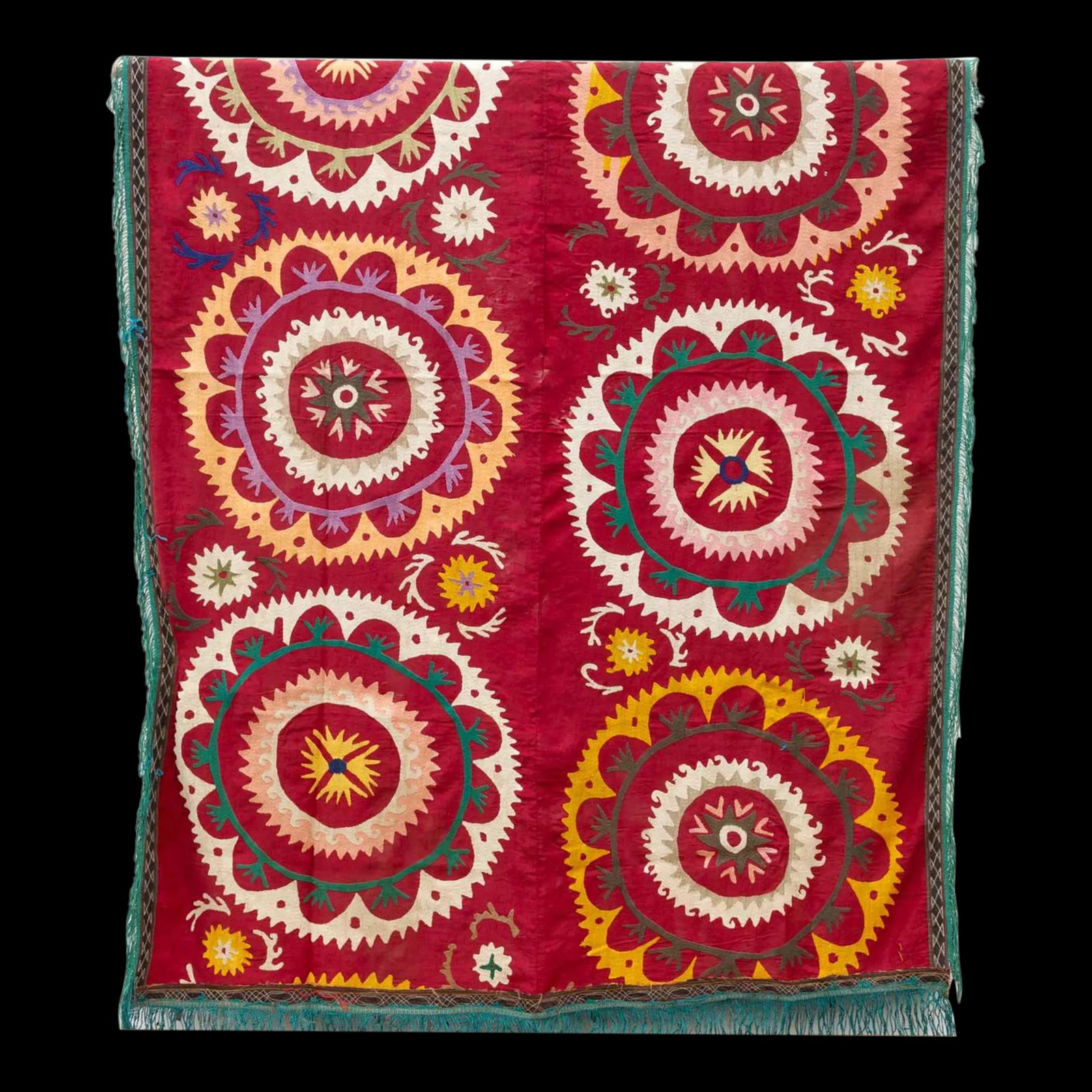 Mid-Century Mandawa Suzani Throw: This colorful vintage Suzani tapestry hails directly from Uzbekistan. The background boasts a luxurious brick red hue, a color traditionally associated with good luck and happiness in Suzani culture.
