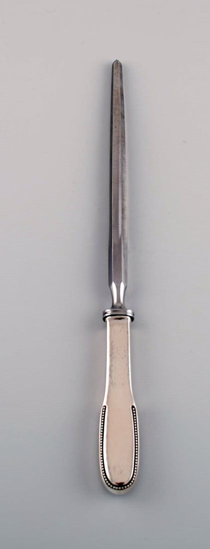 Rare Evald Nielsen number 14 sharpening steel in hammered silver (830) and stainless steel. 1920s.: Title:Rare Evald Nielsen number 14 sharpening steel in hammered silver (830) and stainless steel. 1920s.Brand:Evald NielsenDescription:Rare Evald Nielsen number 14 sharpening steel in hammered silver