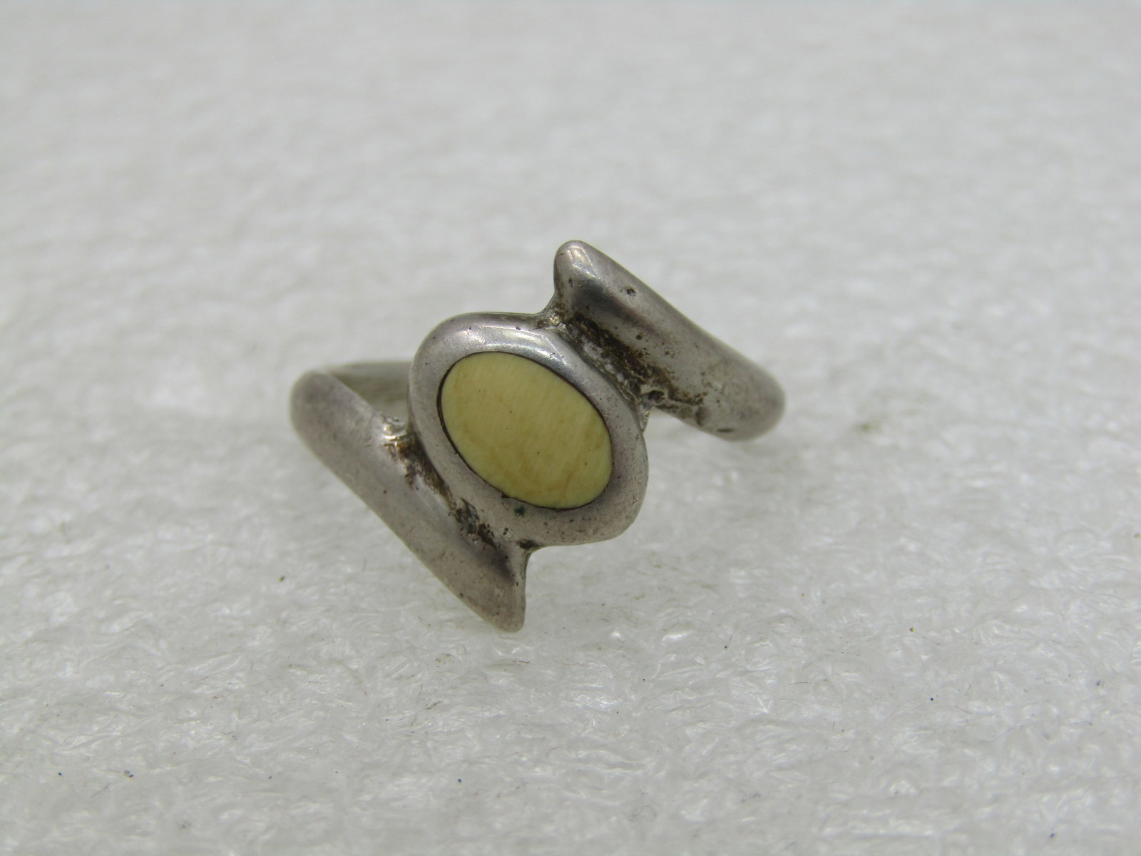 Vintage Sterling Bypass Ring, Oval White/Cream Stone, Sz. 7.5 NL: Vintage Sterling Bypass Ring, Oval White/Cream Stone, Sz. 7.5 . Weight is appx. 4.69 grams. The top of the ring is appx. 7.5mm by 5.5mm and the stone setting is at an angle between the bypass