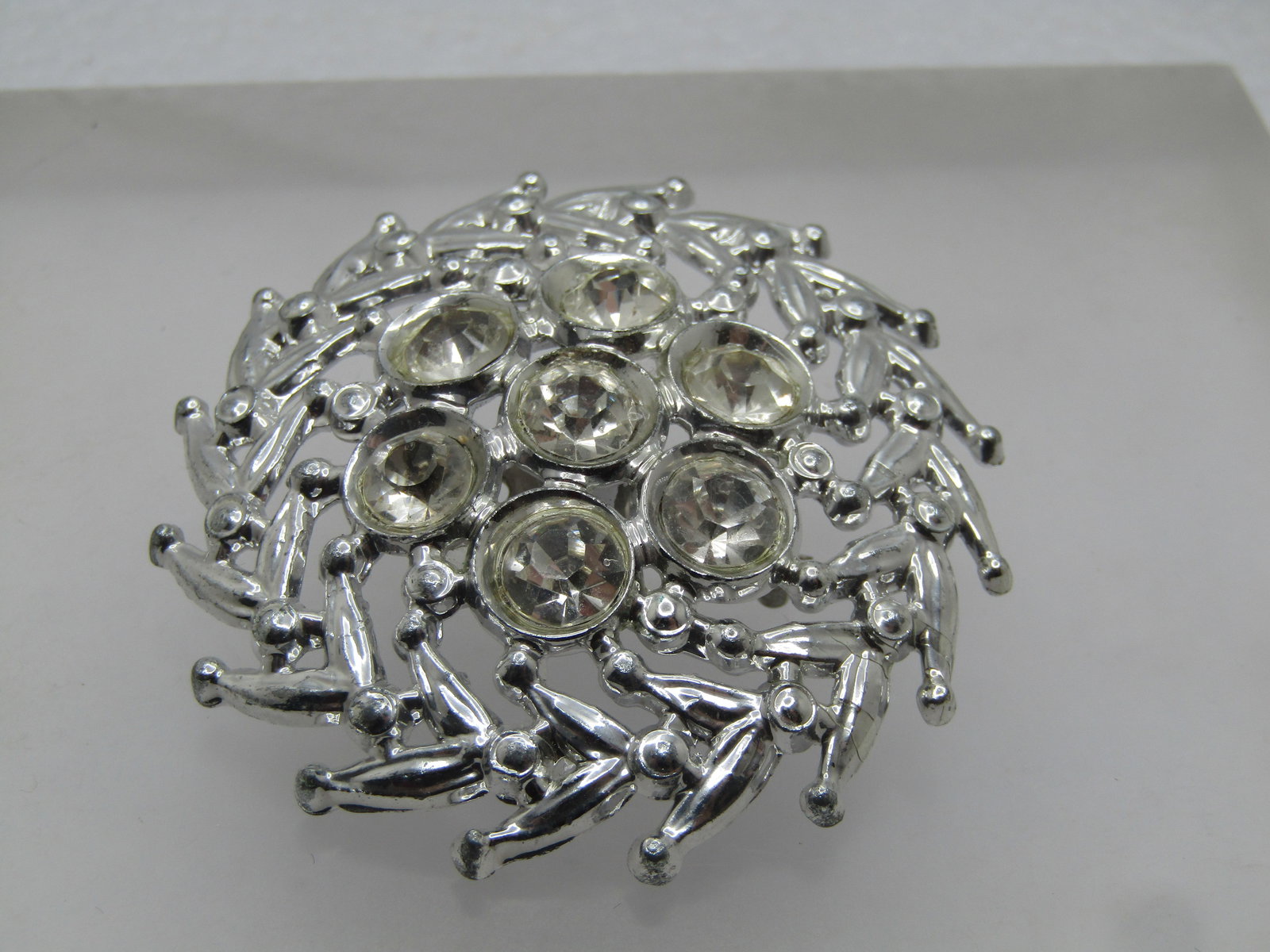 Vintage Domed Round Rhinestone Brooch, 1940's-1950's, 2": Vintage Domed Round Rhinestone Brooch, 1940's-1950's, 2". This is silver tone with V-like accents making up the outer edge with rounded dots on the tips. In the center are seven, appx. 5mm round