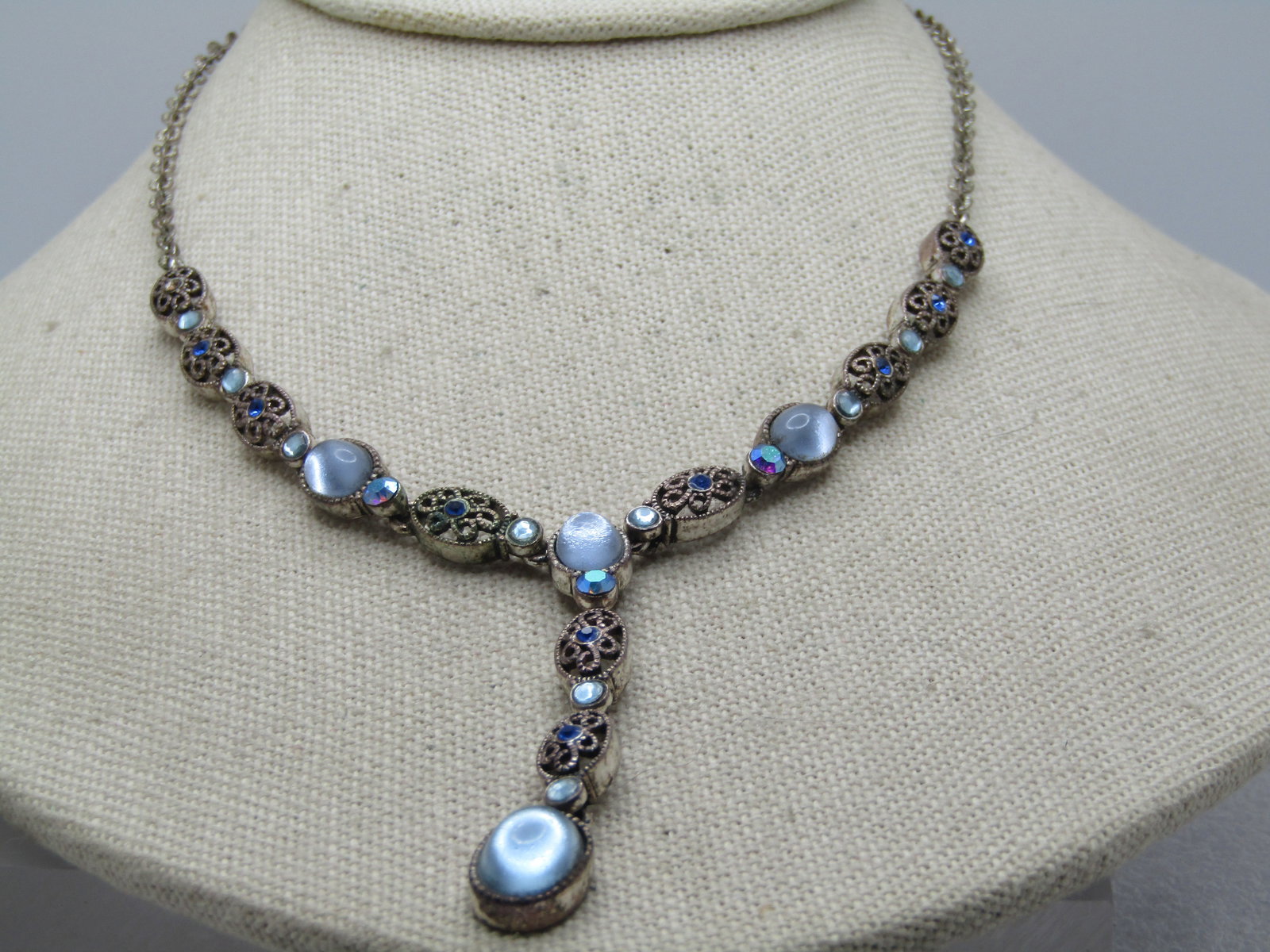 Vintage Blue Rhinestone Filigree Lavalier Necklace, 16", Signed Avon SP: Vintage Blue Rhinestone Filigree Lavalier Necklace, 16", Signed Avon SP, 2003. Shiny blue glass cabochons in some links and filigree oval links with a 2mm dark blue rhinestone. Thre are smaller blue r