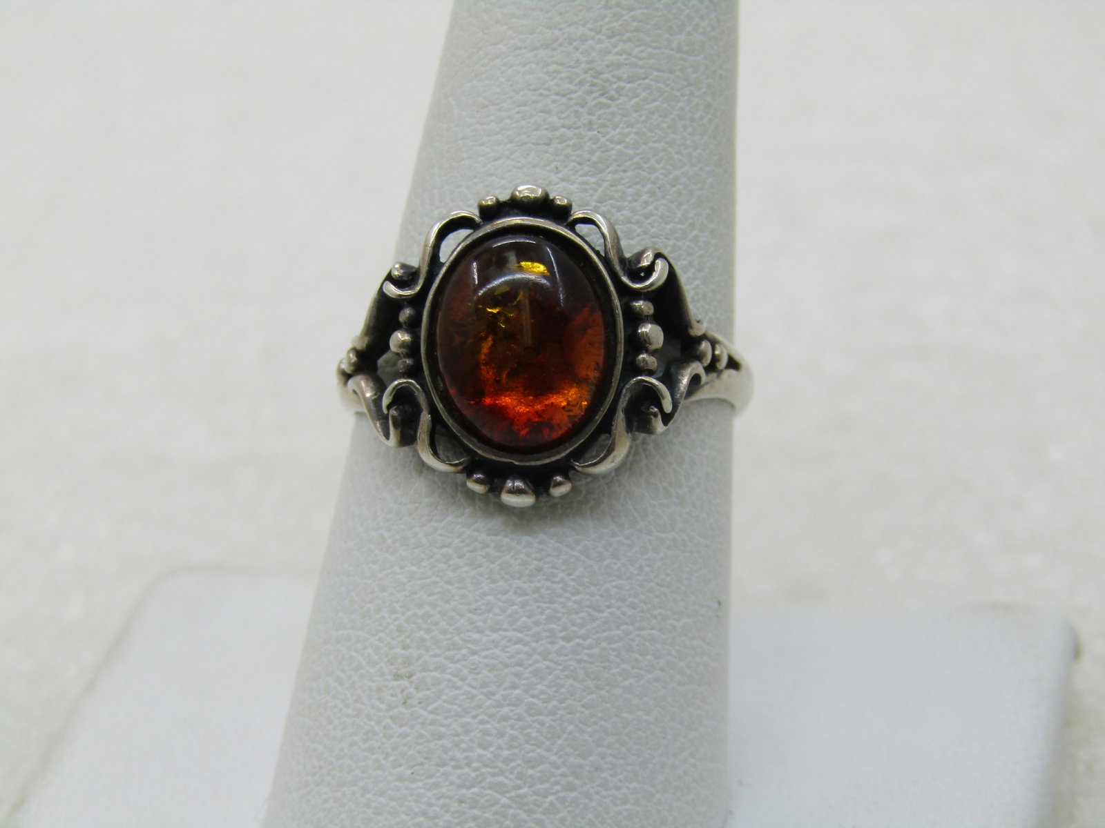 Vintage Sterling Faux Amber Ring, Sz. 8.5, Scrolled: Vintage Sterling Faux Amber Ring, Sz. 8.5, Scrolled. The ring is aoox. 15.5mm down the finger and 16.5mm across the finger with the band being appx. 2.4mm at the back of the finger. It is signed M wit