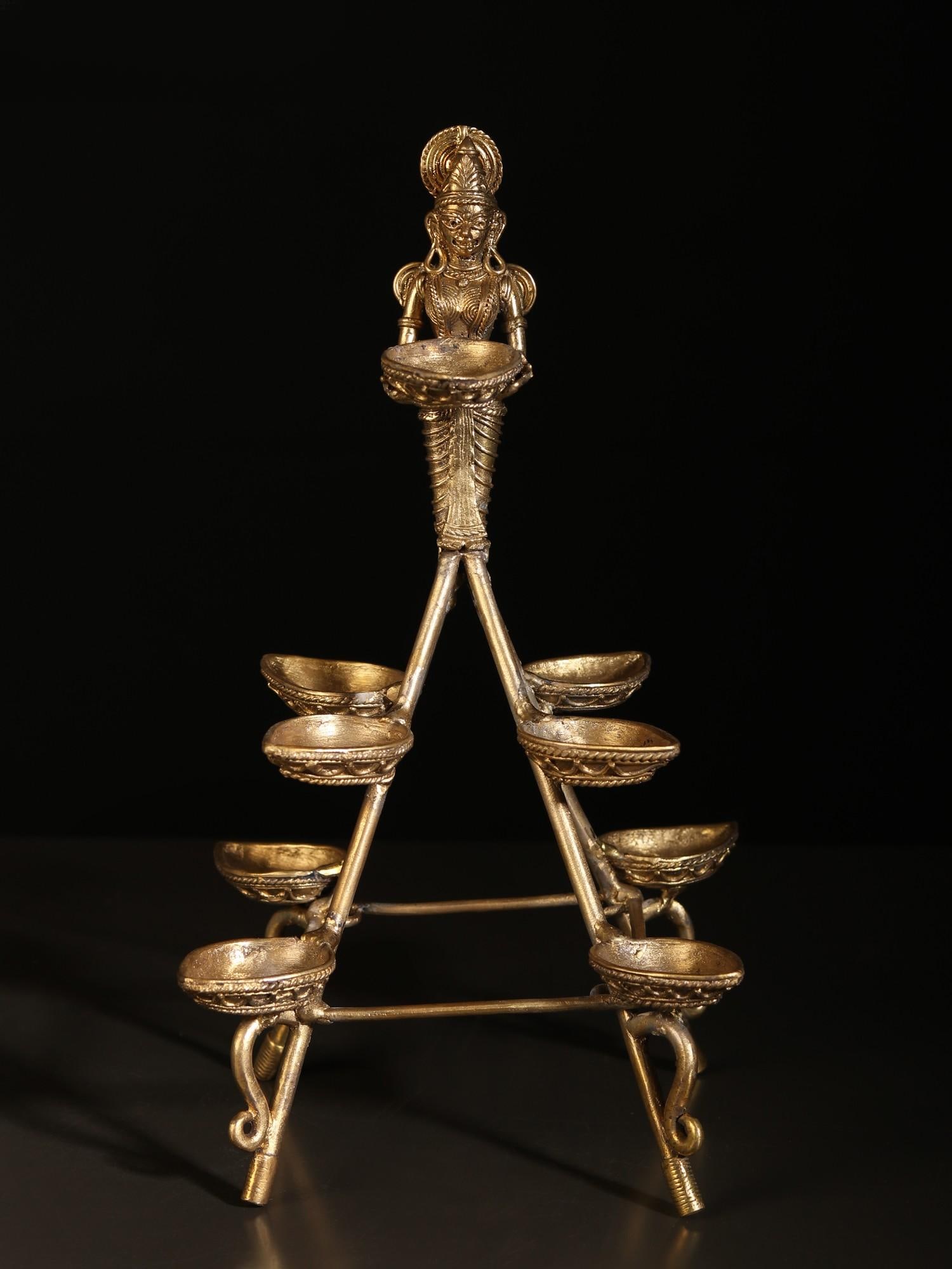 10" Tribal Deep Lakshmi with 9 Wicks Lamp: Title: 10" Tribal Deep Lakshmi with 9 Wicks Lamp Description: This Tribal Deep Lakshmi with Nine Wicks Lamp is a stunning embodiment of tradition and artistry, merging the iconic Deeplakshmi imagery w