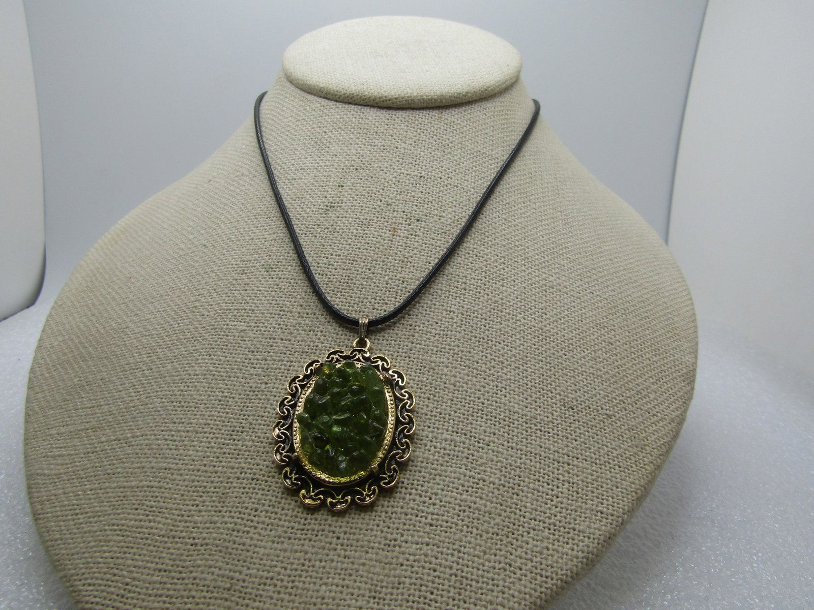 Vintage Green Stone Cluster Necklace, 19", 1960's-1970's: Vintage Green Stone Cluster Necklace, 19", 1960's-1970's. The pendant is gold tone and has a scrolled frame and is appx. 1-5/8" long with the bail and 1-1.8" wide. It has an open center in which there