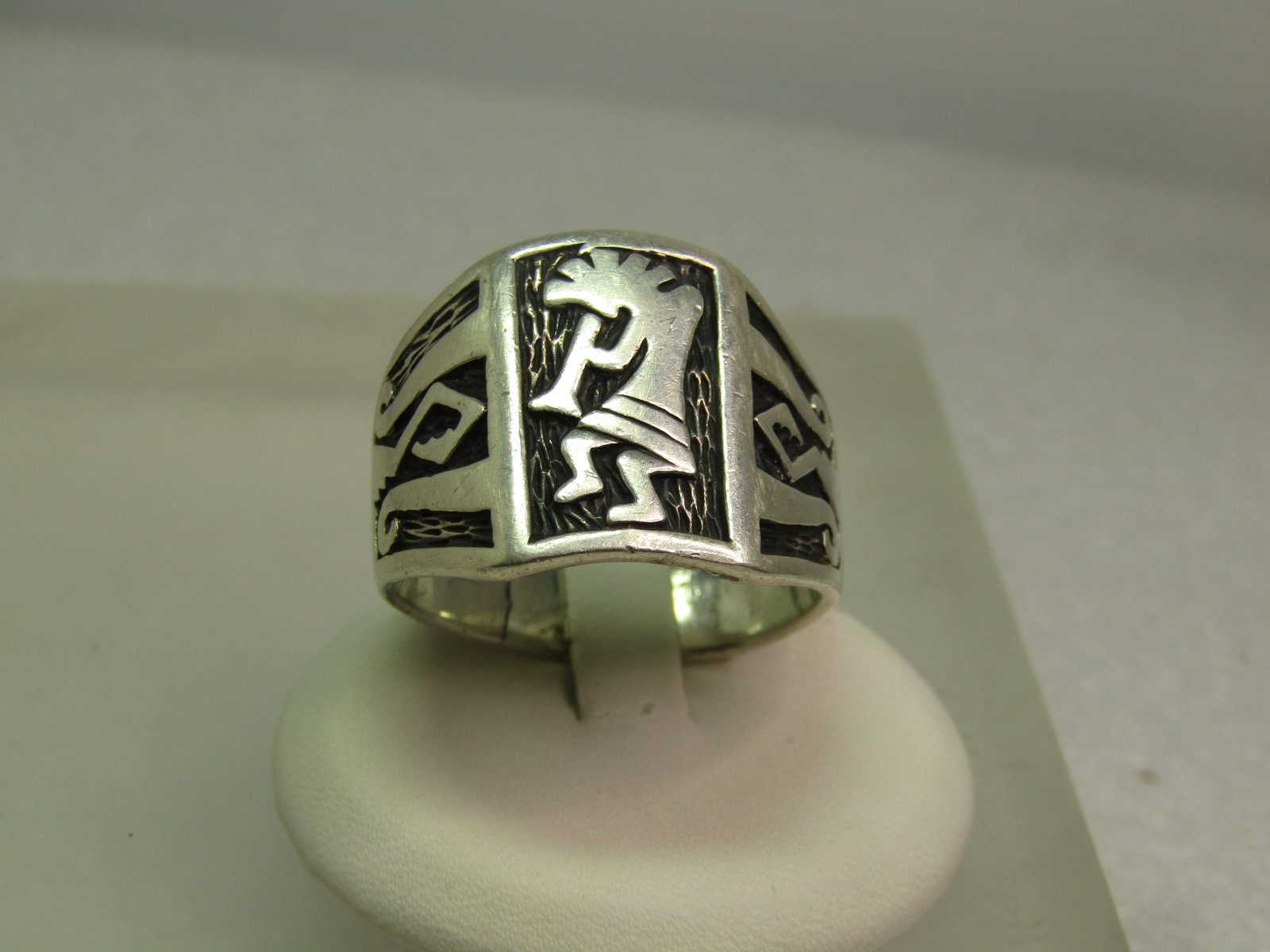 Vintage Sterling Kokopeli Ring, Sz. 14, Wide Statement, 1970's-1980's Signed: Vintage Sterling Kokopeli Ring, Sz. 14, Wide Statement, 1970's-1980's Signed with a $ in a circle. The ring is marked sterling and tests as sterling and appx. 15.10 grams. The ring has a cutout design