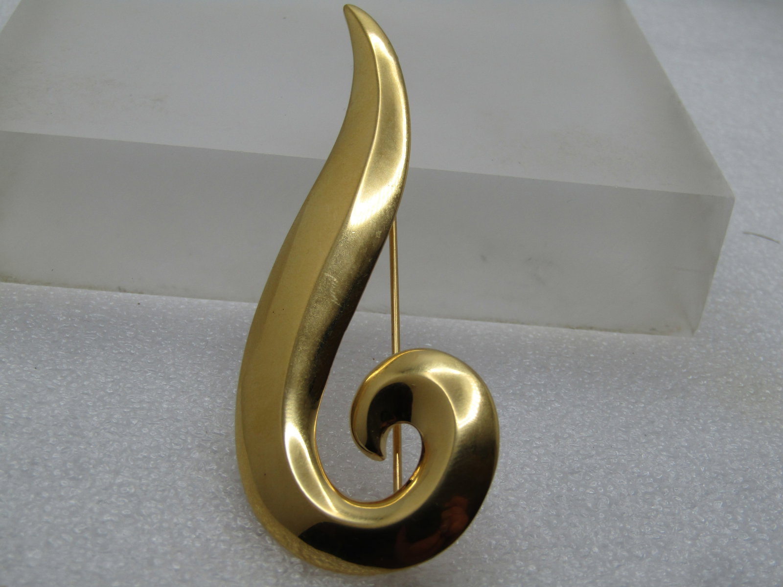 Vintage Monet Long Curved Brooch, Domed Edge, 1960's-1970's: Vintage Monet Long Curved Brooch, Domed Edge, 1960's-1970's. Gold tone with curl on top and pointed on both ends - like a mod question mark. It is appx. 3.25" by 1.25". Signed Monet. It is appx. 5/8" 