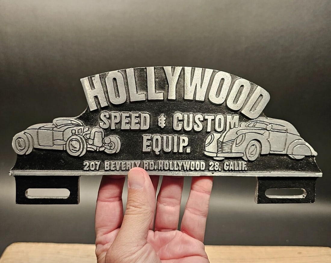 Aluminum Hollywood License Plate Fob Topper: 10 1/2" Wide x 4 1/2" Tall Wonderful reproduction license plate topper. Good detail aluminum, slightly aged to look like an antique. Certainly hard to tell its age. All our items come with a 100% cust