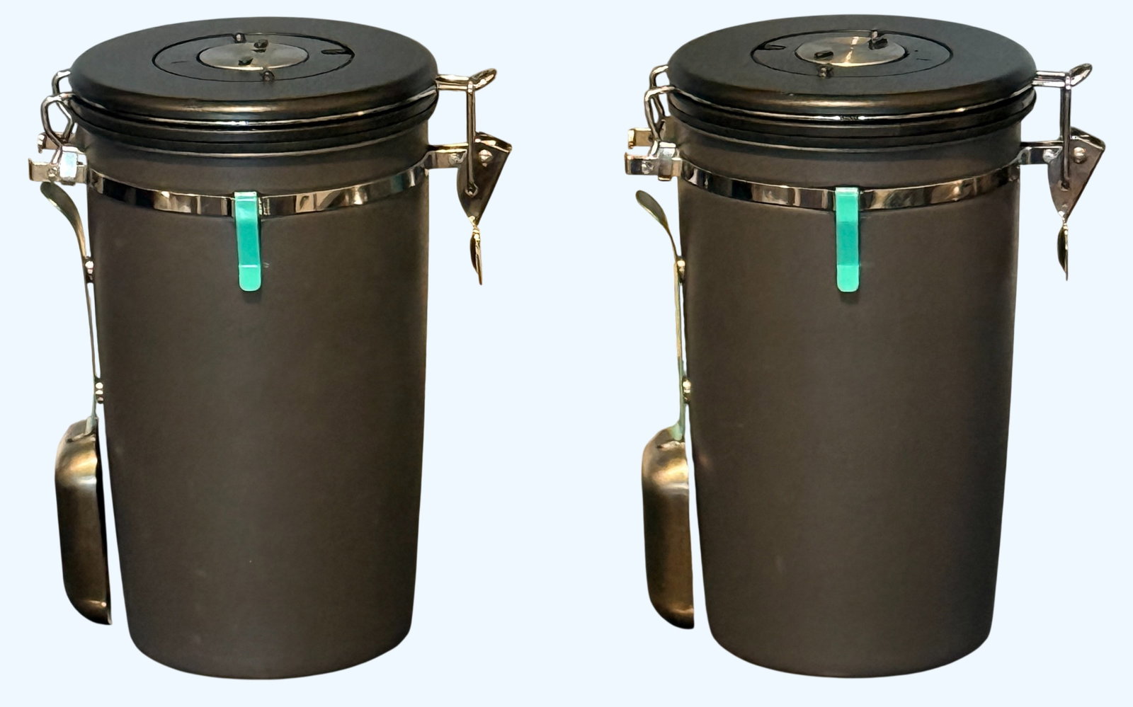 Pair of Modern Air-Tight Coffee Canisters with Scoops: A contemporary pair of air-tight coffee canisters with accompanying scoops. Each canister features a matte dark gray exterior, a stainless steel interior, and a black, hinged lid with a secure clasp m