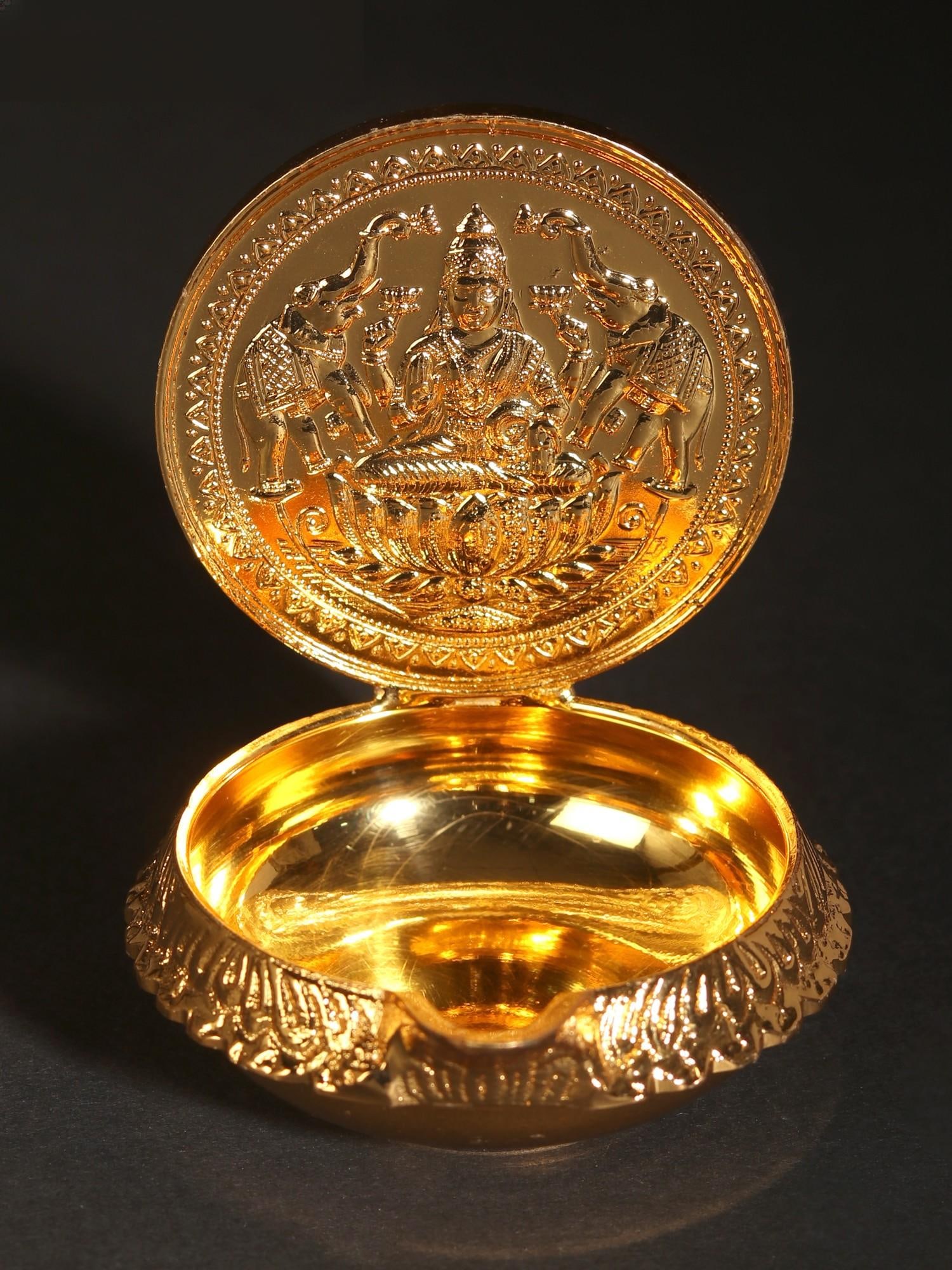 Goddess Gajalakshmi Diya | 24 Karat Gold Coated Brass: Title: Goddess Gajalakshmi Diya | 24 Karat Gold Coated Brass Description: The celestial elephants sprinkle her with water from the golden jar adorned with gems while she holds a lotus in her palm. God