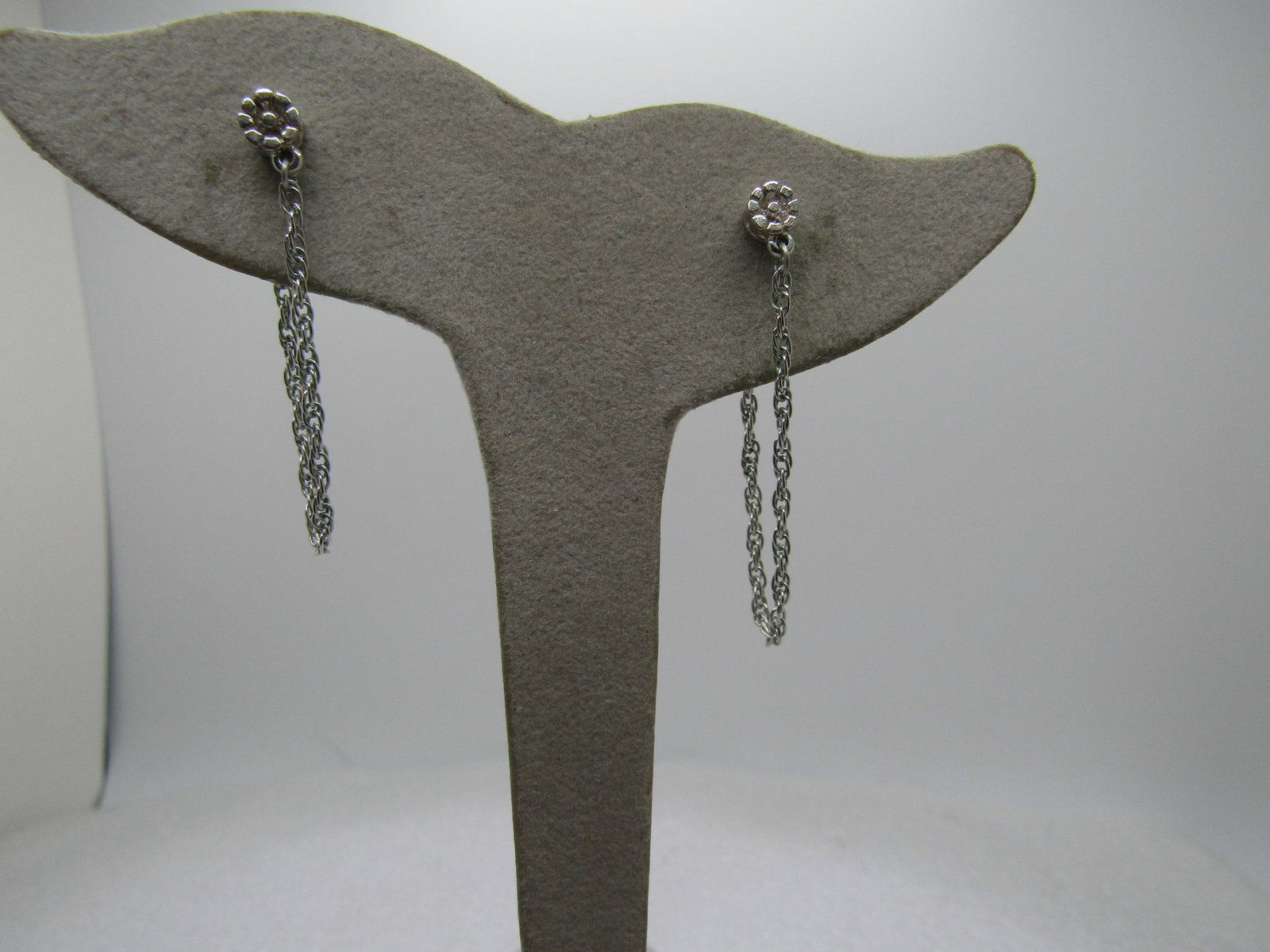 Vintage Monet Silver Tone Blossom Earrings with Chain Loop, 1970's-1980's.: Vintage Monet Silver Tone Blossom Earrings with Chain Loop, 1970's-1980's. The earrings have a 4.5mm blossom stud with a 2.75" chain attached that is also attached to the clutch which makes it have a 