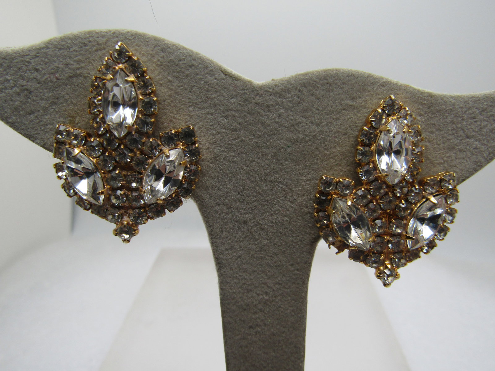 Vintage Rhinestone Clip Earrings, 1980's, Gold Tone: Vintage Rhinestone Clip Earrings, 1980's, Gold Tone. Looks like a leaf with three plates of rhinstone with three marquise in each of the blades of the leave with a hallow of smaller clear rhinestones 