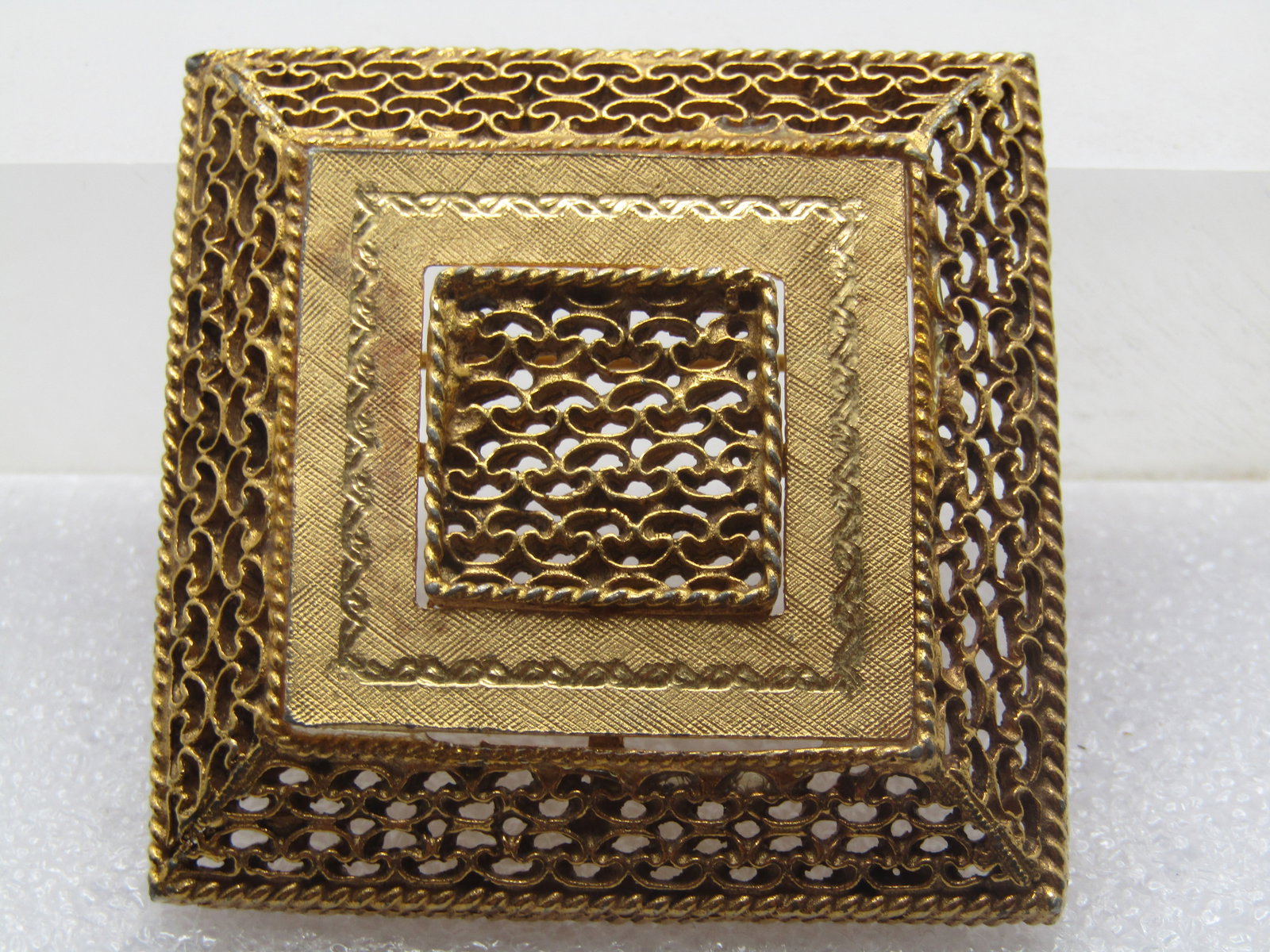 Vintage Filigree Tiered Square Brooch, 1960's-1970's: Vintage Filigree Tiered Square Brooch, 1960's-1970's. This has a tapered filigree outer frame and square center frame with rope accent and also a flat etched design around the center. The brooch is go