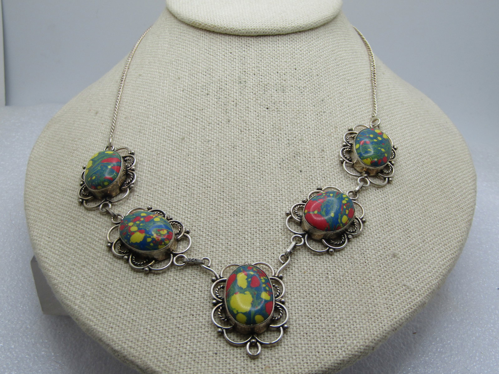 Vintage Faux Agate Necklace, 17.5", Southwestern Themed, 1990's: Vintage Faux Agate Necklace, 17.5", Southwestern Themed, 1990's. This is silver tone metal with a scrolled and rope accent frame around green, red, yellow faux agates. They are made of resin or a p