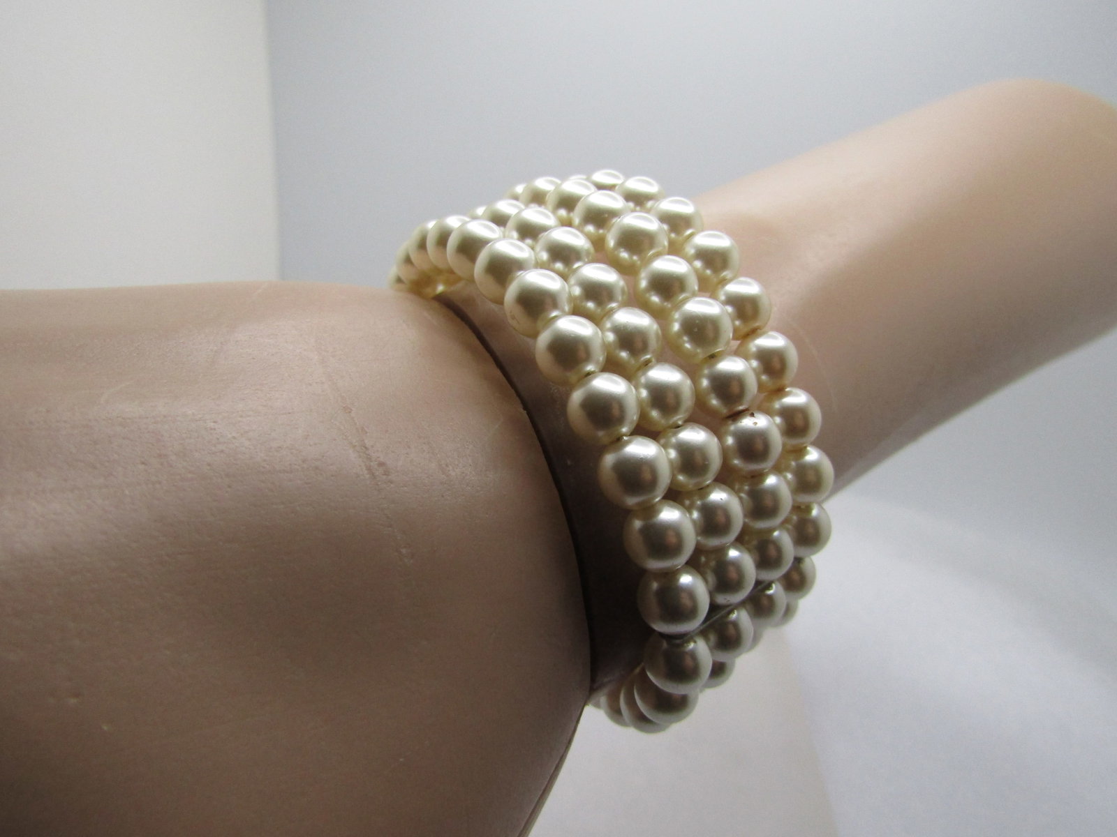 Vintage Faux Pearl Coiled Bracelet, Four Strands, 6"-7", 1960's-1970's: Vintage Faux Pearl Coiled Bracelet, Four Strands, 6"-7". The bracelet is appx. 1" wide, Coils around the wrist and easy to slide on and off. It is 6" with ends meeting but can stretch to 7" and worn