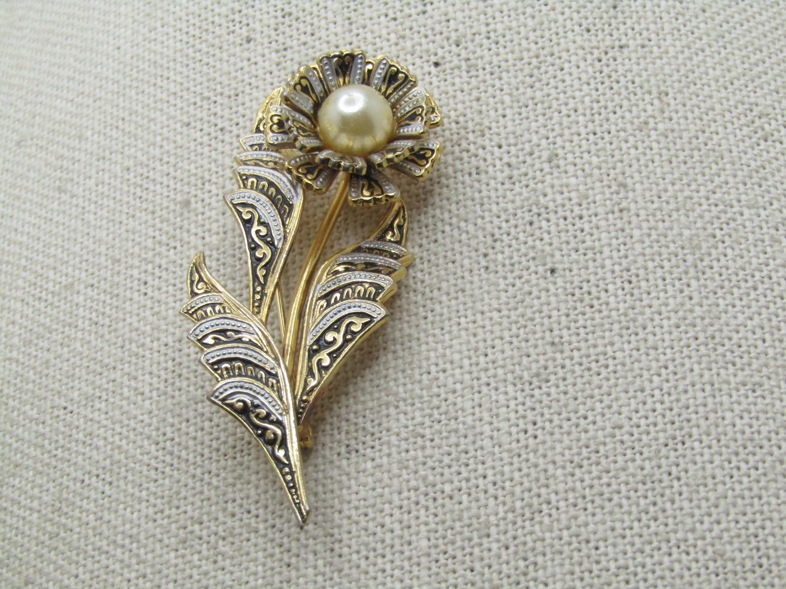 Vintage Damascene Floral Brooch, Faux Pearl, 1960's-1970's, 2-1/8": Vintage Damascene Floral Brooch, Faux Pearl, 1960's-1970's, 2-1/8" tall and appx. 7/8" wide. Black, white and black enameling on gold tone floral stem brooch with an appx 7mm faux pearl in the center 