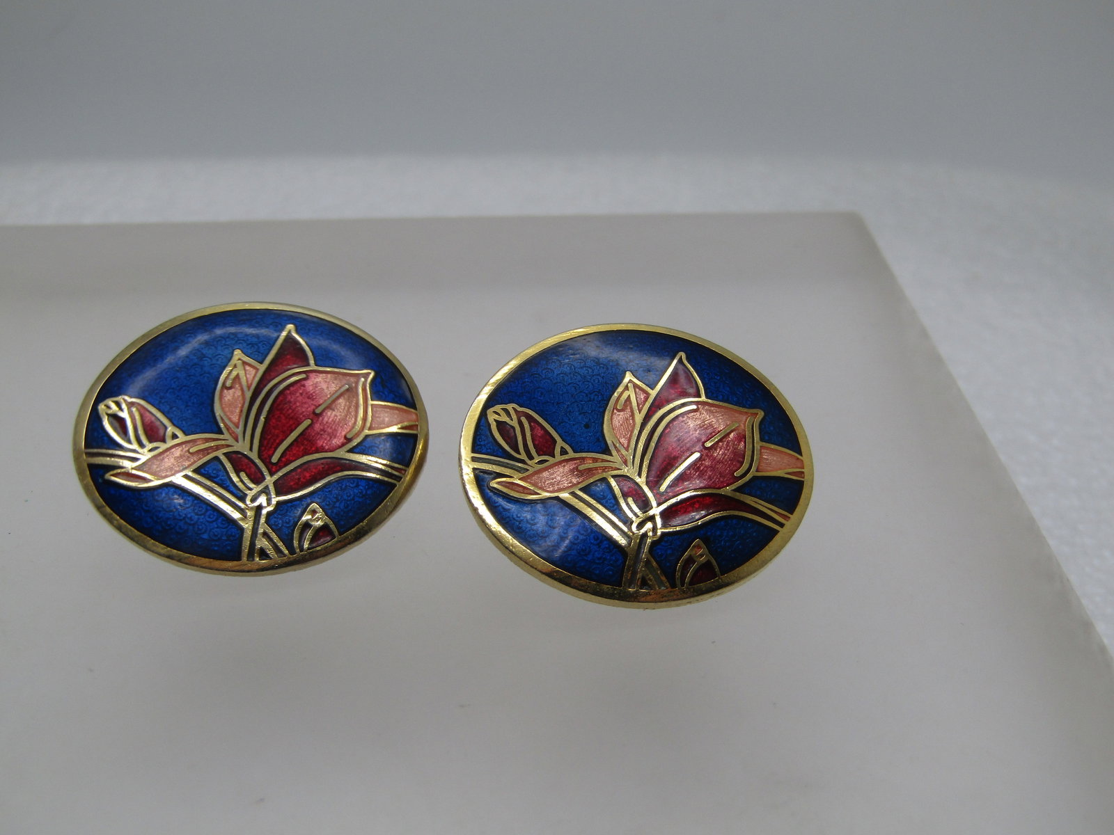 Vintage Cloisonne Floral Earrings, Round, Pierced, Signed SITI, 1970's-1980's: Vintage Cloisonne Floral Earrings, Round, Pierced, Signed SITI, 1970's-1980's. These are appx. 1" wide and slightly domed with a blue background and peach to pink/red blossoms. Signed SITI. Gold tone.