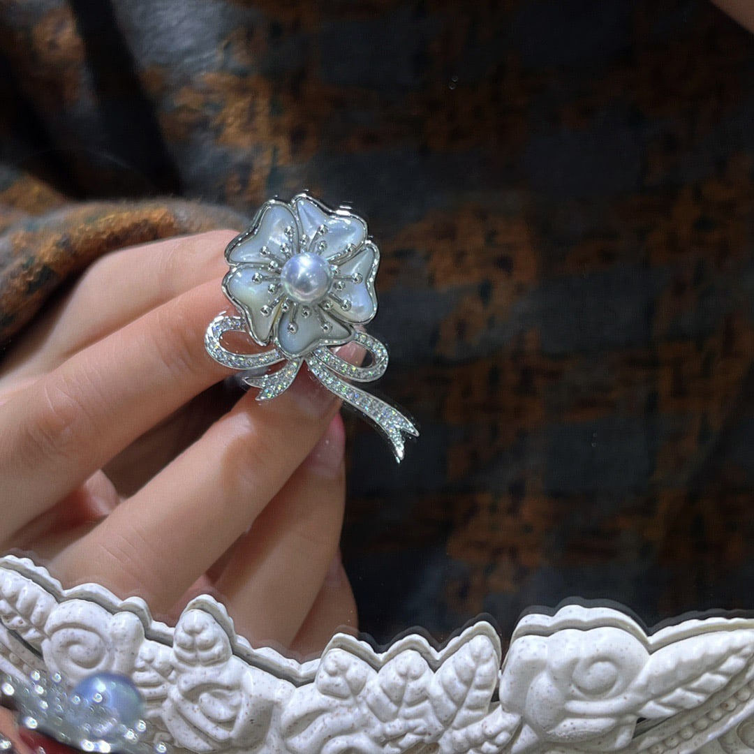 Seawater Pearl Brooch: Title: Seawater Pearl Brooch Description: This brooch features a meticulously crafted floral design paired with 7-8mm seawater pearls, showcasing natural luster and elegance. Its minimalist and