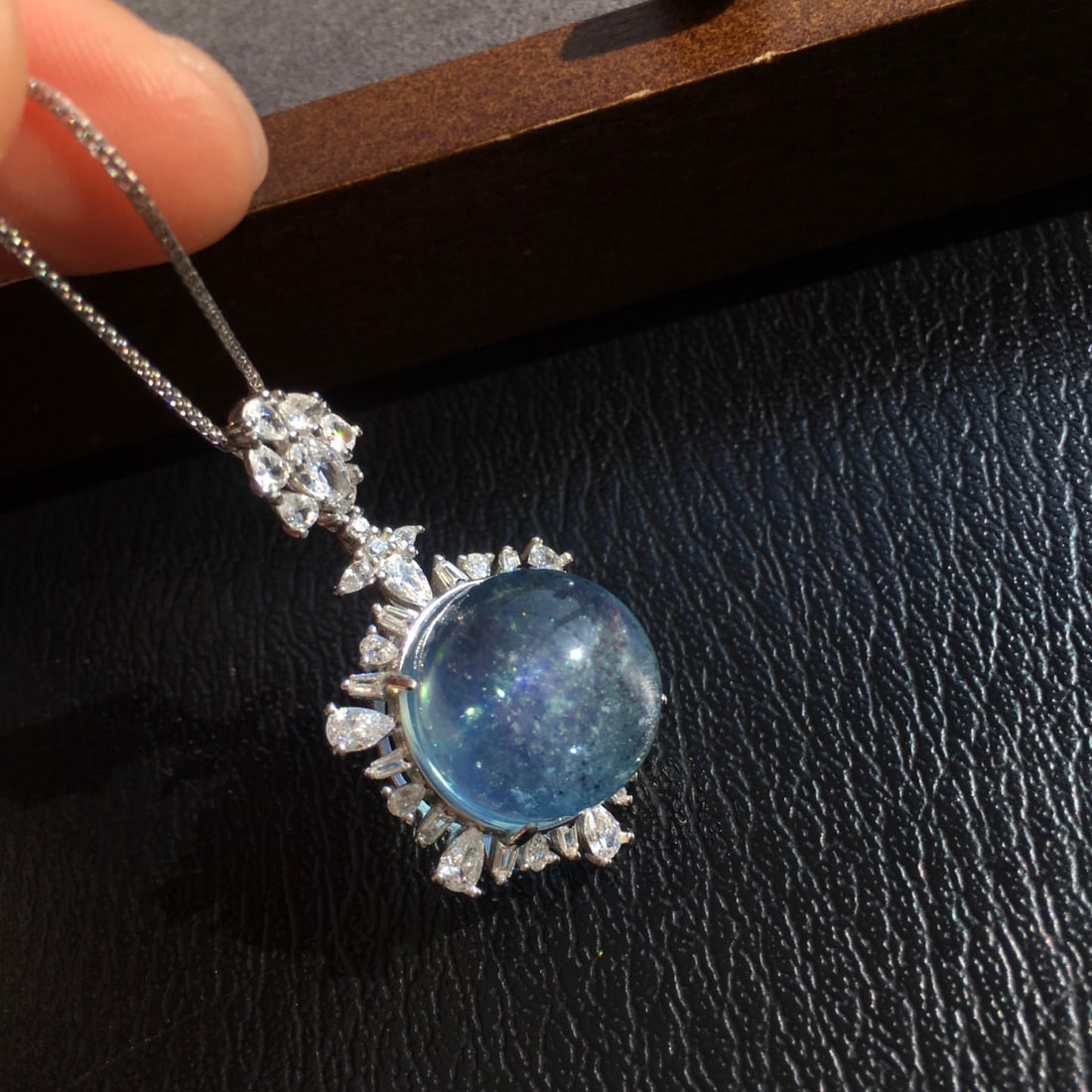 925 Silver Aquamarine Pendant: Title: 925 Silver Aquamarine Pendant Description: This pendant is meticulously set in 925 silver, featuring a natural aquamarine with rich golden and cool white hues. The crystal's transparency and