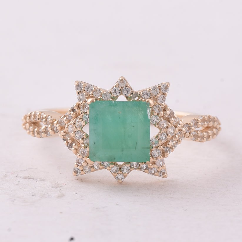 1.15 Ct Square Emerald 9K Gold Ring: 1.15 Total Carat Emerald 9K Gold Ring Specifications: Total Weight 1.773 g Center Gemstone Emerald Gemstone Carat Weight 0.84 Carats Gemstone Measurements 6X6 mm Additional Gemstones White Sapphire