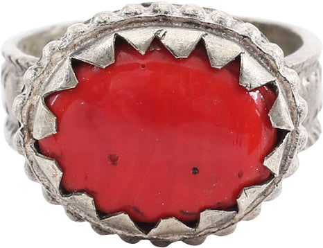 EASTERN EUROPEAN GYPSY WOMAN’S RING, SIZE 8 1/2: 19th century. White metal/base silver. 6.1mm band with raised edges and raised egg and dart medial motif. White metal bezel with hound’s tooth banding and beaded base, set with an oval red