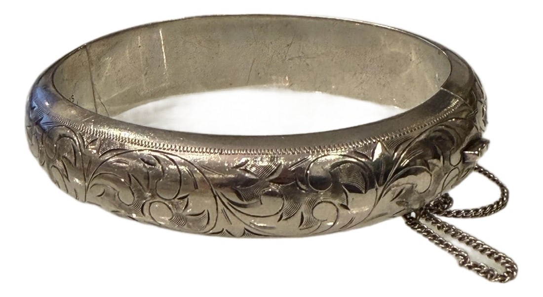 Vintage Art Nouveau Style Hinged Bangle Bracelet in Sterling Silver: Vintage Art Nouveau style hinged bangle bracelet with etching. This lovely 950 sterling bracelet has an elegant leaf and scroll design and a secure clasp and safety chain. It is stamped "STERLING" in
