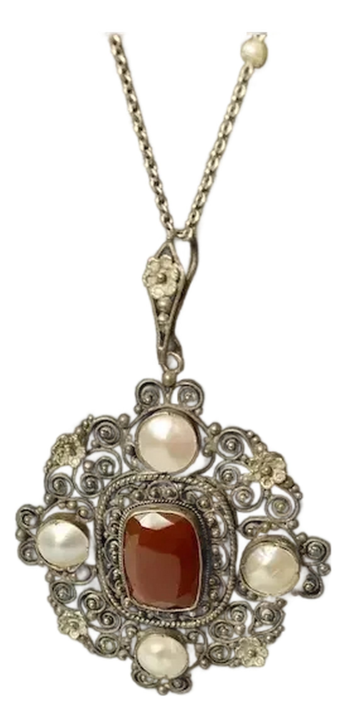 Late 19th Century Victorian Carnelian Sterling Mabe Pearl Necklace: Intricate Victorian sterling pendant. Amazing filigree work on the pendant featuring a faceted carnelian surrounded by four mabe pearls. Two seed pearls enhance the chain. The pendant measures 2 1/4"