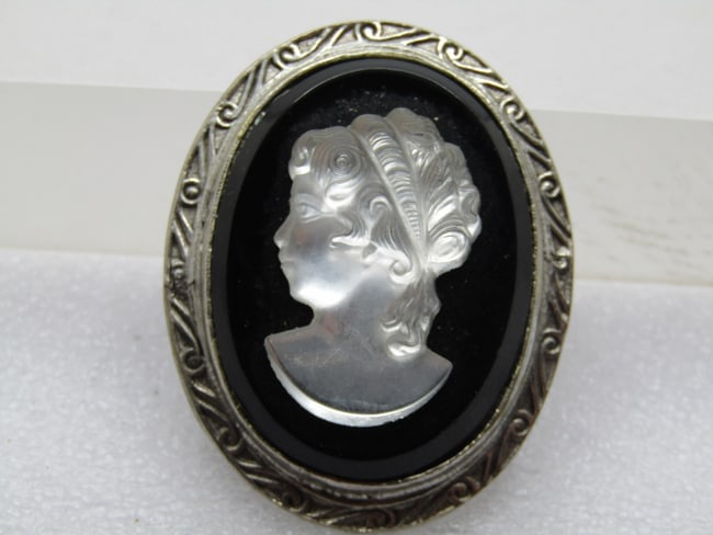 Vintage Black & White Cameo Brooch, Glass, 1960's: Vintage Black & White Cameo Brooch, 1960's. It is appx. 2" by 1.5". The cameo portion is a pressed white glass with a black glass background. Stamped design in the frame, bezel-set. It is appx. 2" tal