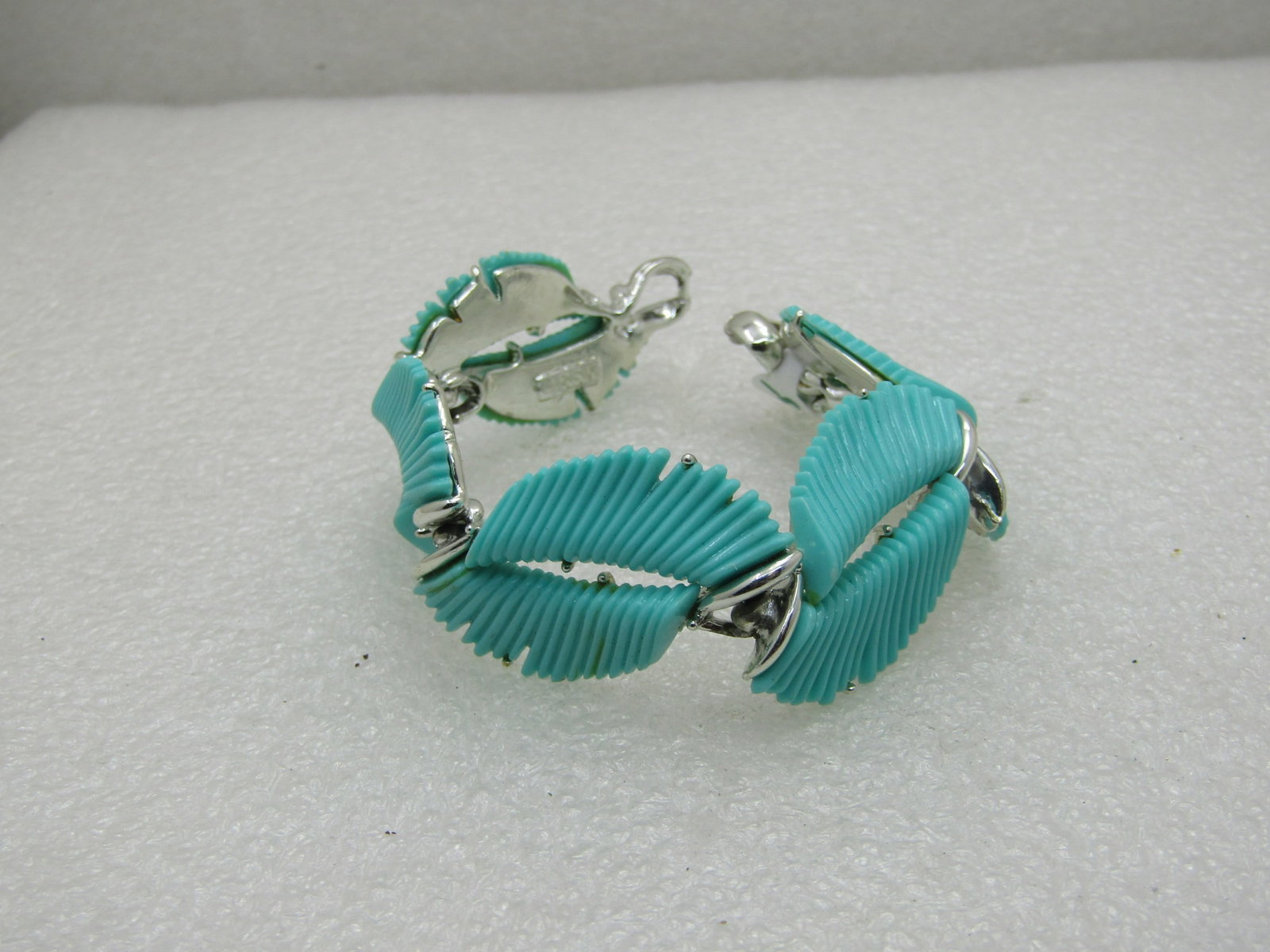 Vintage BSK Turquoise Lucite Feathered Bracelet, 7.5",: Vintage BSK Turquoise Lucite Feathered Bracelet, 7.5", Silver tone. Slightly over 1" wide, flipover clasp. There are five links with teal feathered lucite links that are open in the center and set an 
