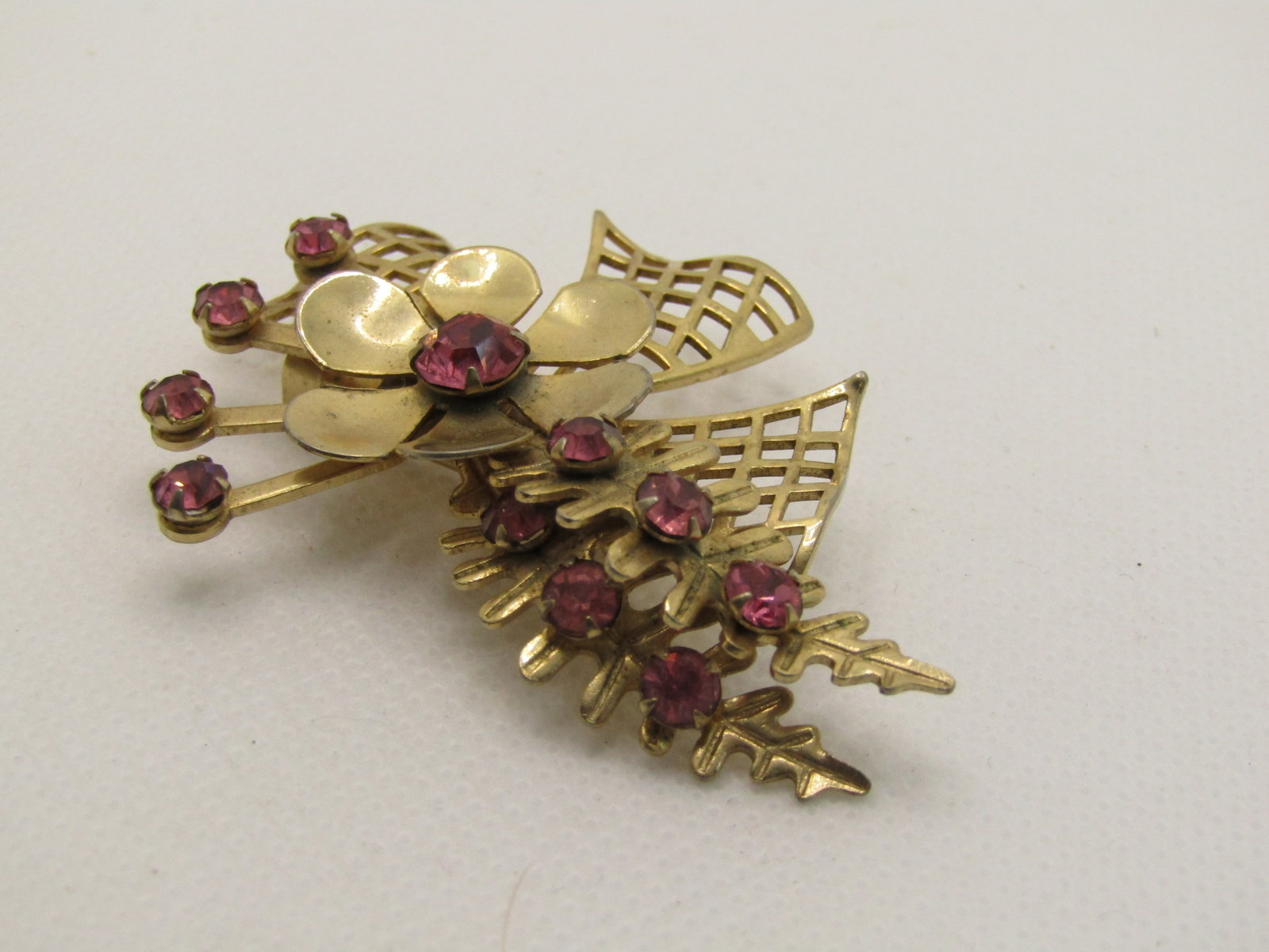 Vintage 1960's Rhinestone FlorMod Brooch, 2.25": Vintage 1960's Rhinestone Floral Mod Brooch, 2.25" by 1.75. Pink rhinestones accent this floral and mod style 1960's brooch with an open grid bow, floral blossom, rhinestone accents on the leaves and