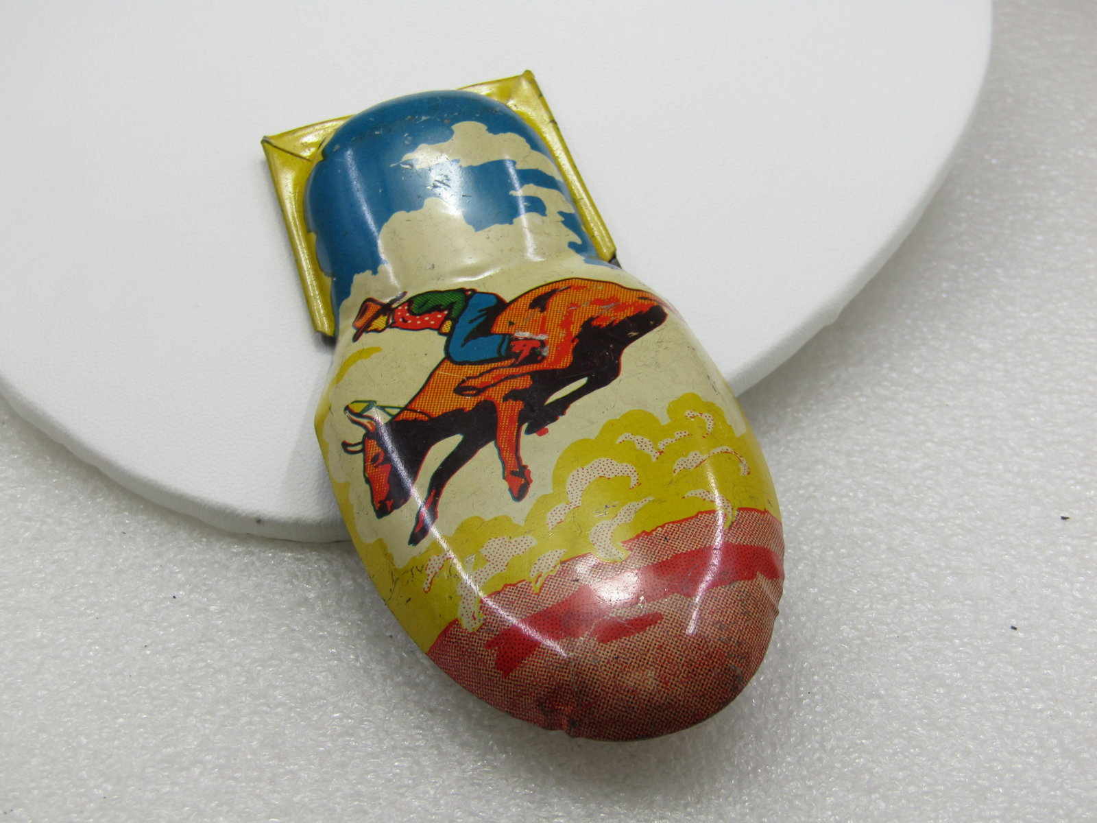 Vintage Kirchhof Litho Bullrider Large Clicker Toy: Vintage Kirchhof Litho Bullrider Large Clicker Toy, 4.5" long 2" wide, very nice cowboy scene with prairie and sky included. 1950's. Very good condition with only light wear. (INV W36-1321.8 SS4574 J