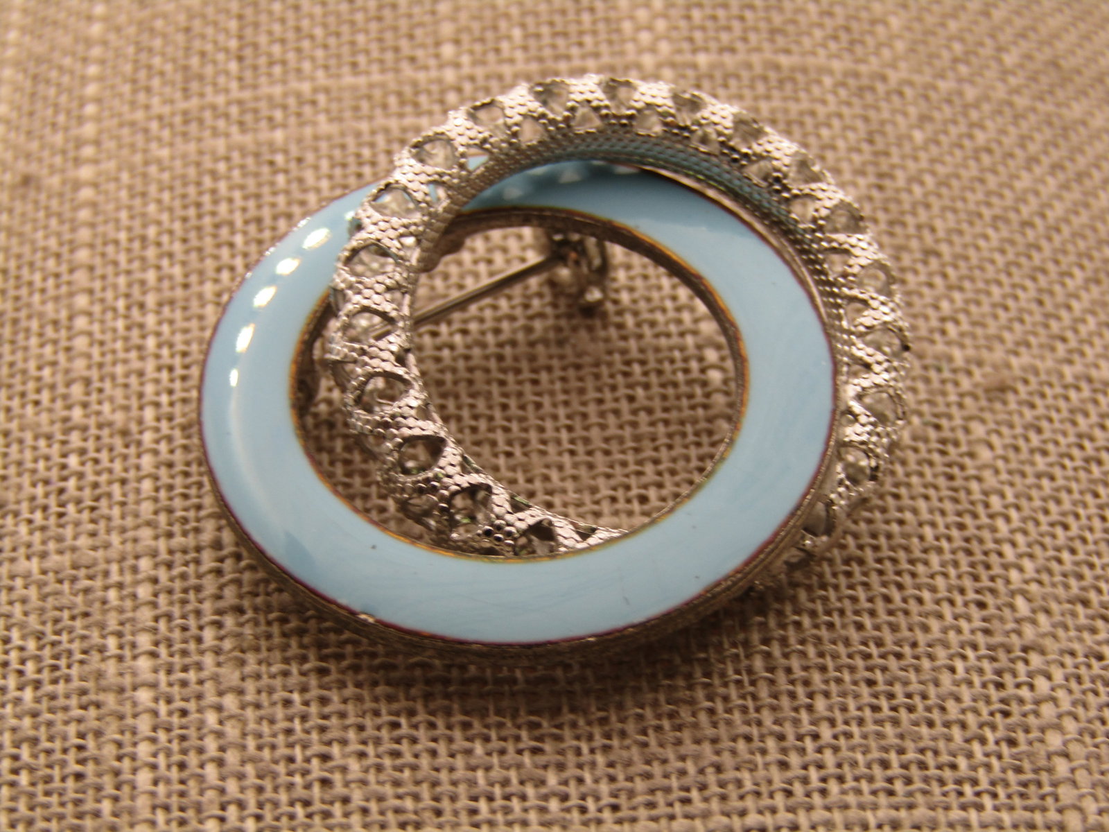 Vintage Aqua Enameled Double Circle Brooch, 1960's: Vintage Aqua Enameled Double Circle Brooch, 1960's, Double circle brooch with a tex tured open rounded silver tone circle intertwined with an aqua enameled circle. 1-3/8" wide and 1.25" tall. Not