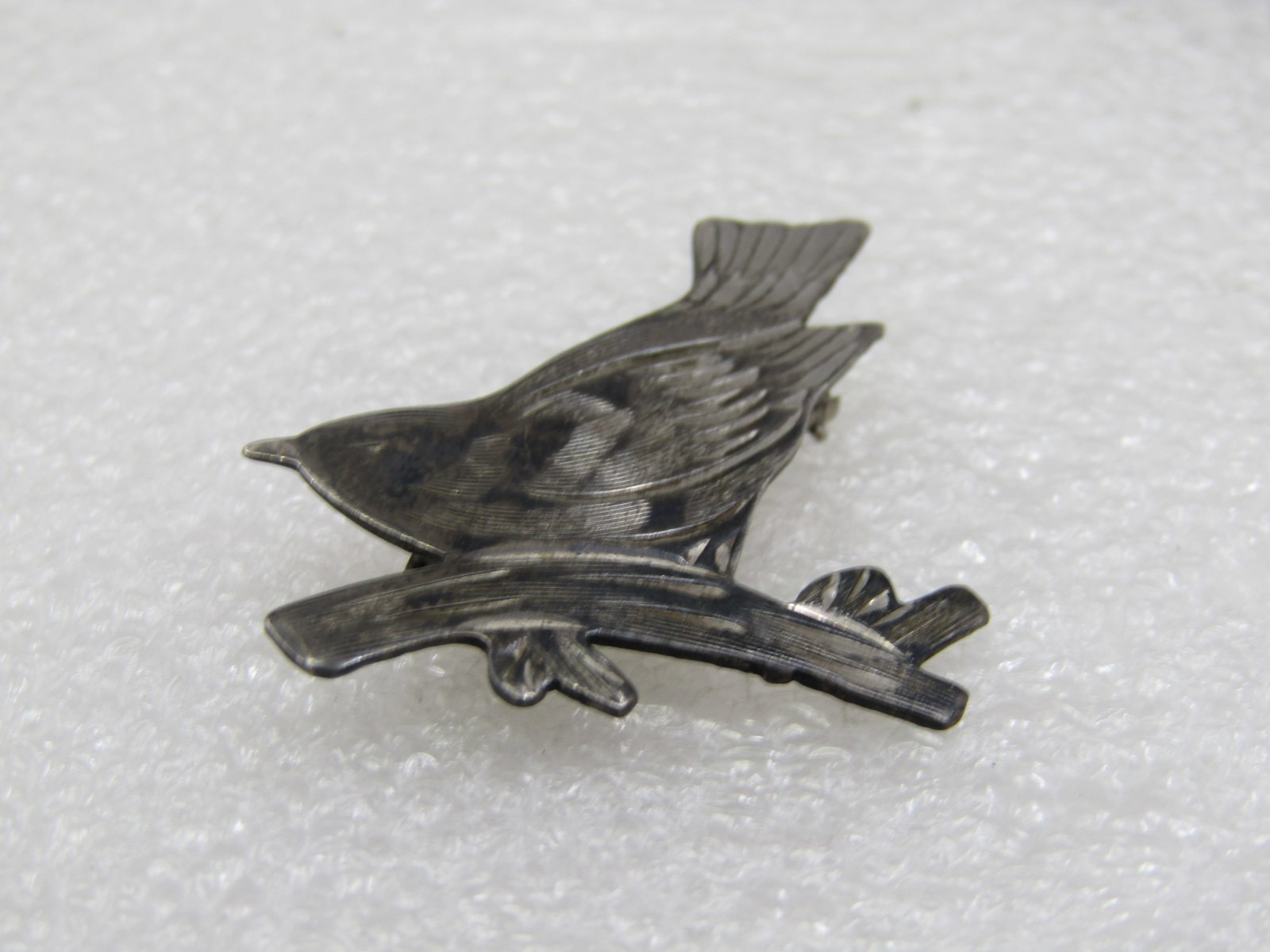 Vintage Sterling Bird on Branch Brooch, 1940's-1950's: Vintage Sterling Bird on Branch Brooch, 1940's-1950's. I.5" by 1.25", a bird with it's tail up high as it sits on a branch. It is marked sterling and tested. Weight is appx. 3.68 gr. Very good
