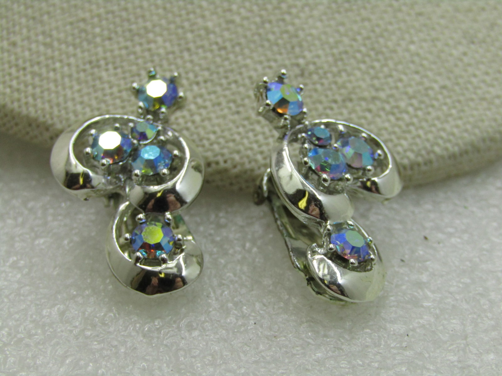 Vintage Aurora Borealis Rhinestone Clip Earrings, 1960's: Vintage Aurora Borealis Rhinestone Clip Earrings, 1960's. Spiral framing with center mounted aurora borealis rhinestones in rainbow shimmers. The earrings are gold tone and appx. 1-1/8" long and 5/8" 
