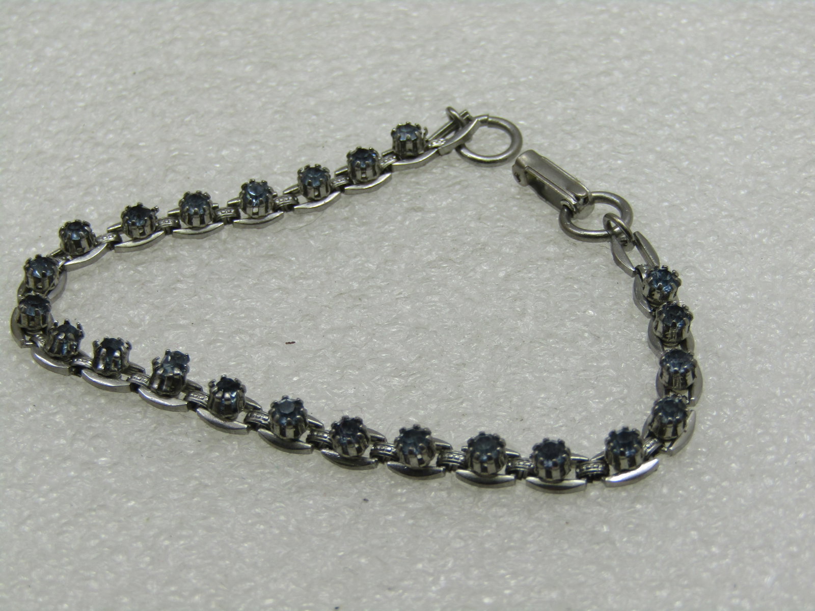 Vintage Blue Rhinestone Tennis Bracelet, 7.25", 1970's-1980's: Vintage Blue Rhinestone Tennis Bracelet, 7.25", 1970's-1980's, 4.5mm wide, hinged flip clasp. Oval links with raised appx. 3mm wide. Good condition. Not signed by the maker. (INV. W.5121.6 SS4629 J