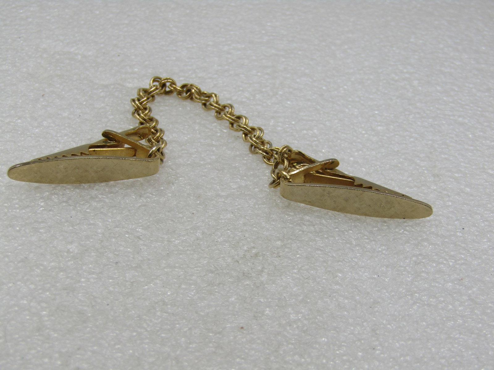 Vintage Gold Tone Sweater Guard, 7": Vintage Gold Tone Sweater Guard, 7". The clips are appx. 1.25" textured finish with a double textured link chain. Not signed by the maker but marked with Pat. 2853781 which was issued in September 195