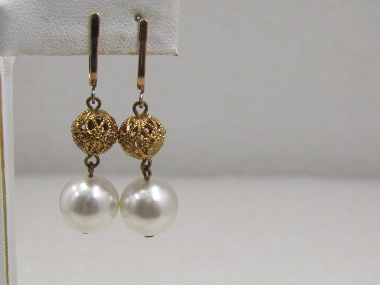 Vintage Filigree Pearl Dangle Earrings, Screwback, 1960's: Vintage Filigree Pearl Dangle Earrings, Screwback, 1960's. Gold tone or plated with a wire front to look like pierced earrings. A filigree 8mm drops from the wire and below that, an 11.5mm faux white