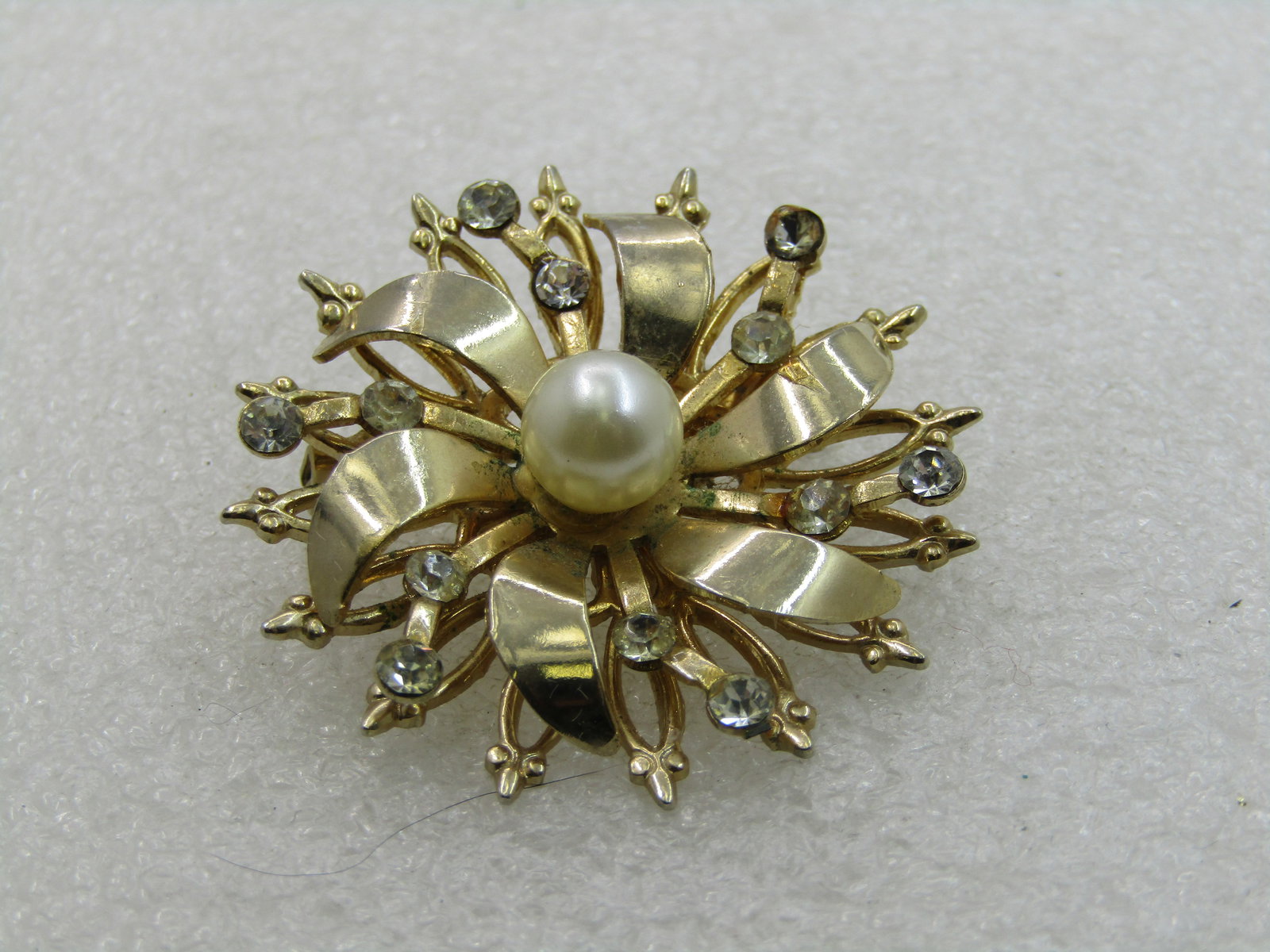 Vintage Rhinestone & Faux Pearl Brooch, Blossom/Snowflake, 1960's: Vintage Rhinestone & Faux Pearl Brooch, Blossom/Snowflake, 1960's. 1.5" across with a center 7.5mm faux pearl and rhinestoines on the second lowest tier. The brooch has a triple tier with the second
