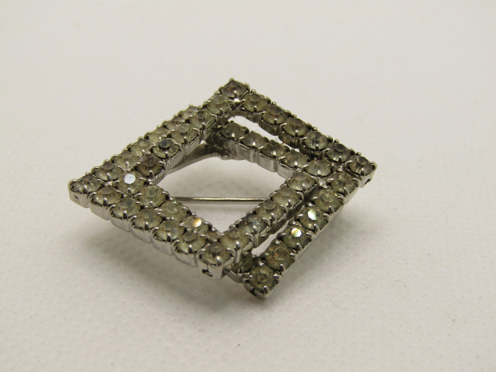 Vintage Rhinestone Intersecting Square Framed Brooch, 1": Vintage Rhinestone Intersecting Square Framed Brooch, 1". 1960's. Silver Tone. Not signed by the maker. Good to very good condition. (INV. W. 82220.4 SS4466 J LD 4/24/21). Reserve: $15.00 Shipping: