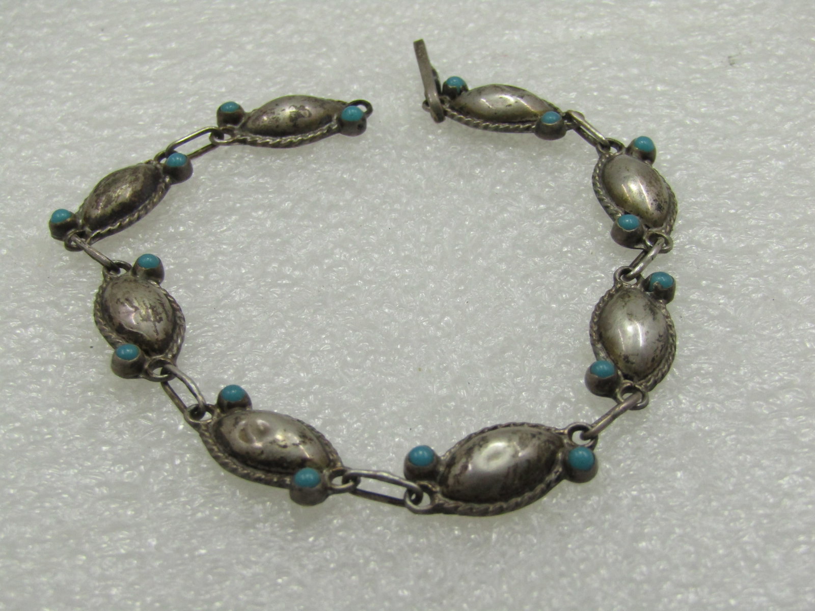 Vintage Sterilng Turquoise Taxco, Mexico Bracelet 7.5", 1970's: Vintage Sterilng Turquoise Taxco, Mexico Bracelet 7.5", 1970's, 8mm wide. Southwestern/Mexican fibe with puffy cateye links with rope accents and a turquoise snake eye stone on opposite ends of each l