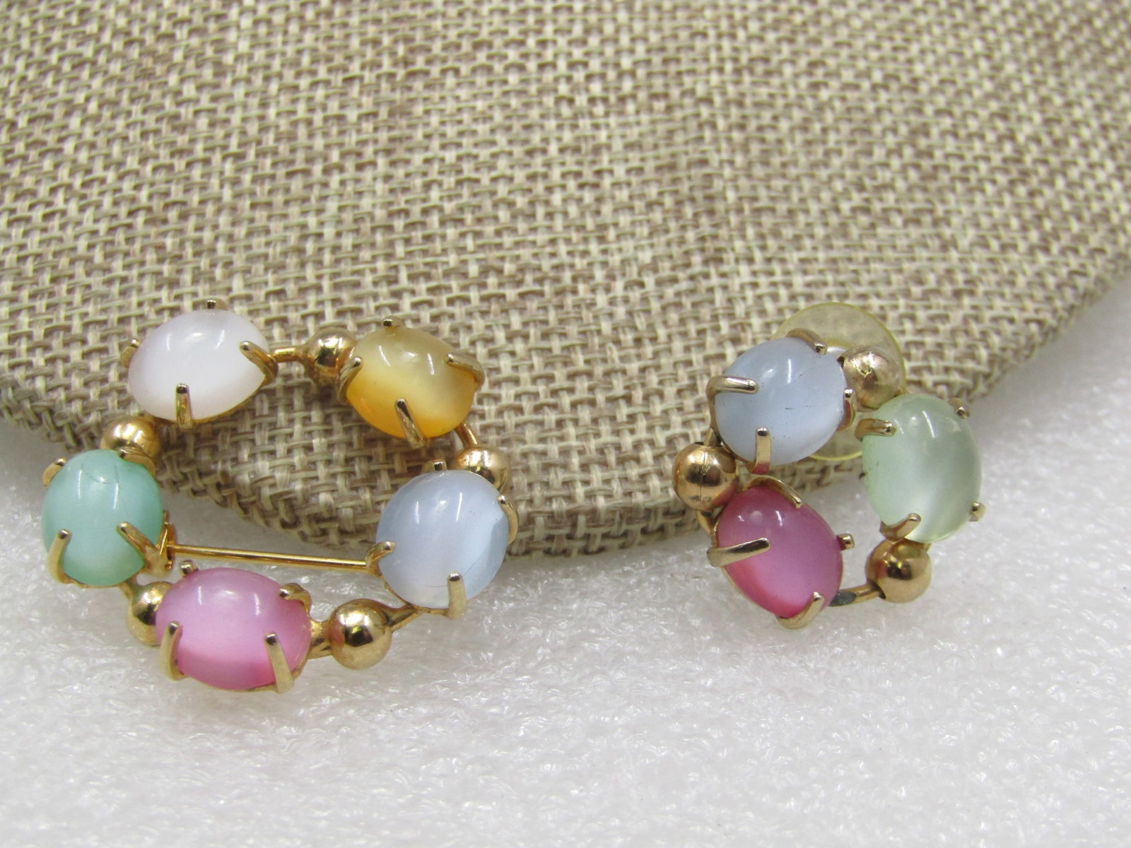Vintage Pastel Cateye Glass Brooch and Single Earring, 1960's: Vintage Pastel Cateye Brooch and Single Earring, 1960's. The brooch is a circle boorch with pong set pink, yellow, blue, green scarab-like smooth stones that are apx. 9.5mm by 8mm with a gold bead