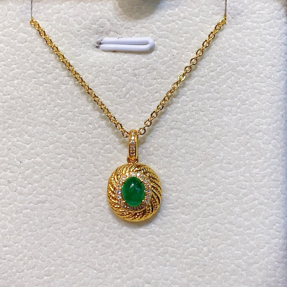 18K Gold Natural Emerald Pendant: Title: 18K Gold Natural Emerald Pendant Description: This pendant is crafted in 18K gold, featuring a natural emerald with a rich golden hue and transparent crystal, exhibiting minimal blemishes. The