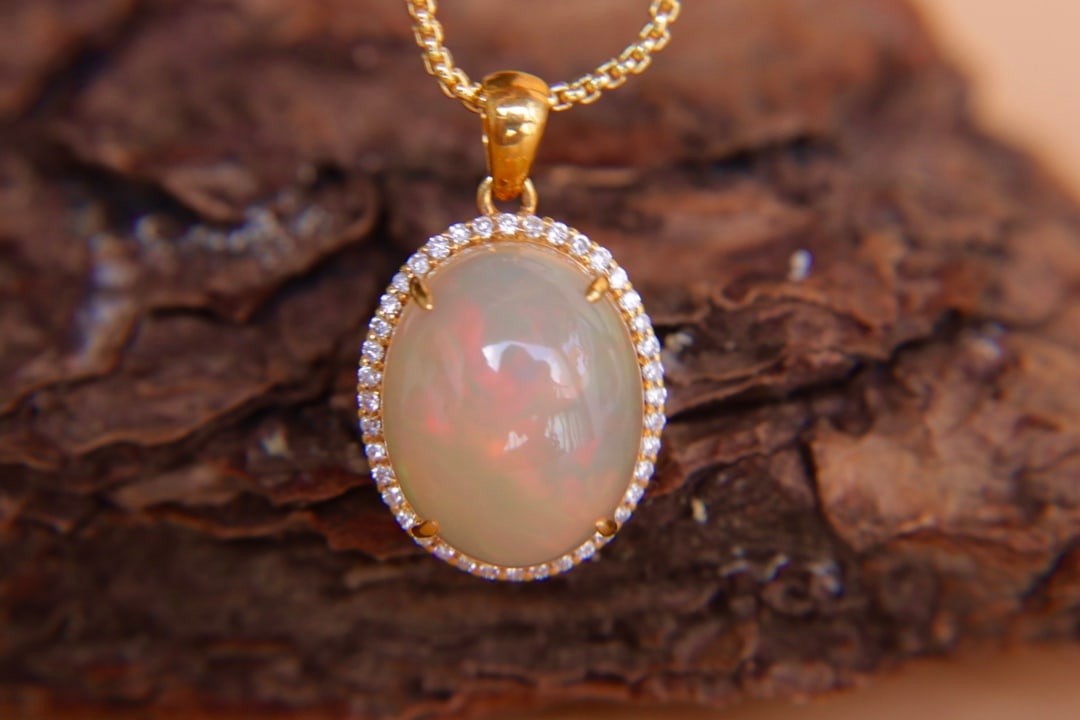 18K Gold Natural Opal Diamond Pendant: Title: 18K Gold Natural Opal Diamond Pendant Description: This pendant features 18K gold set with natural opal and diamonds. The main stone is 6.2 carats, showcasing a rich golden hue with a cool