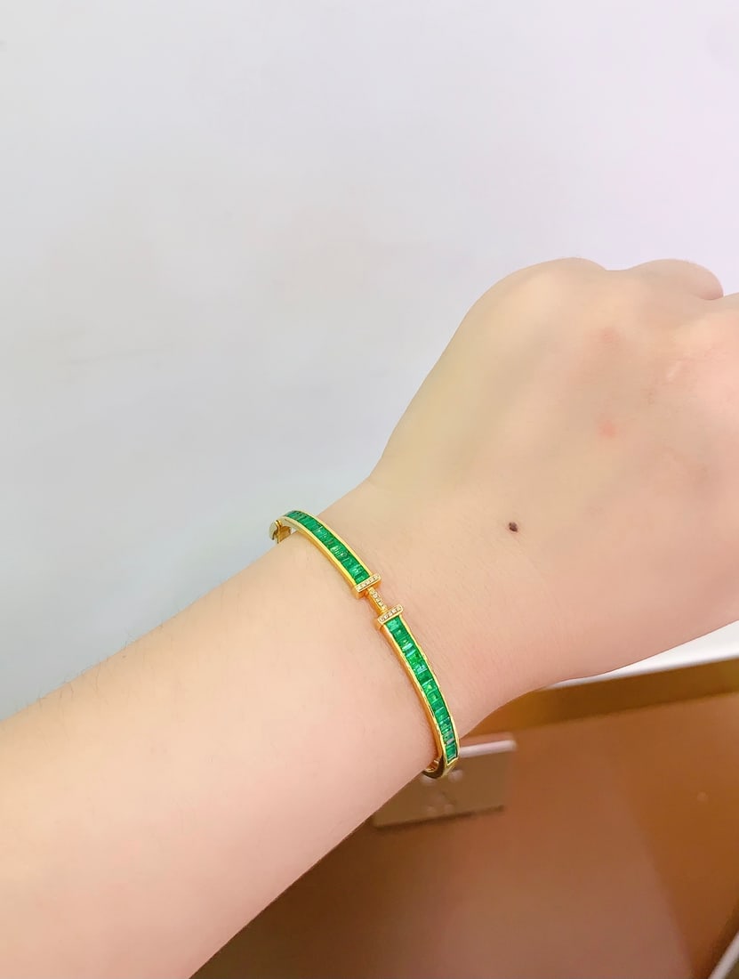 18K Gold Natural Emerald Bracelet: Title: 18K Gold Natural Emerald Bracelet Description: This bracelet features an 18K gold base adorned with a natural emerald, showcasing a perfect blend of rich gold and cool white. The emerald's
