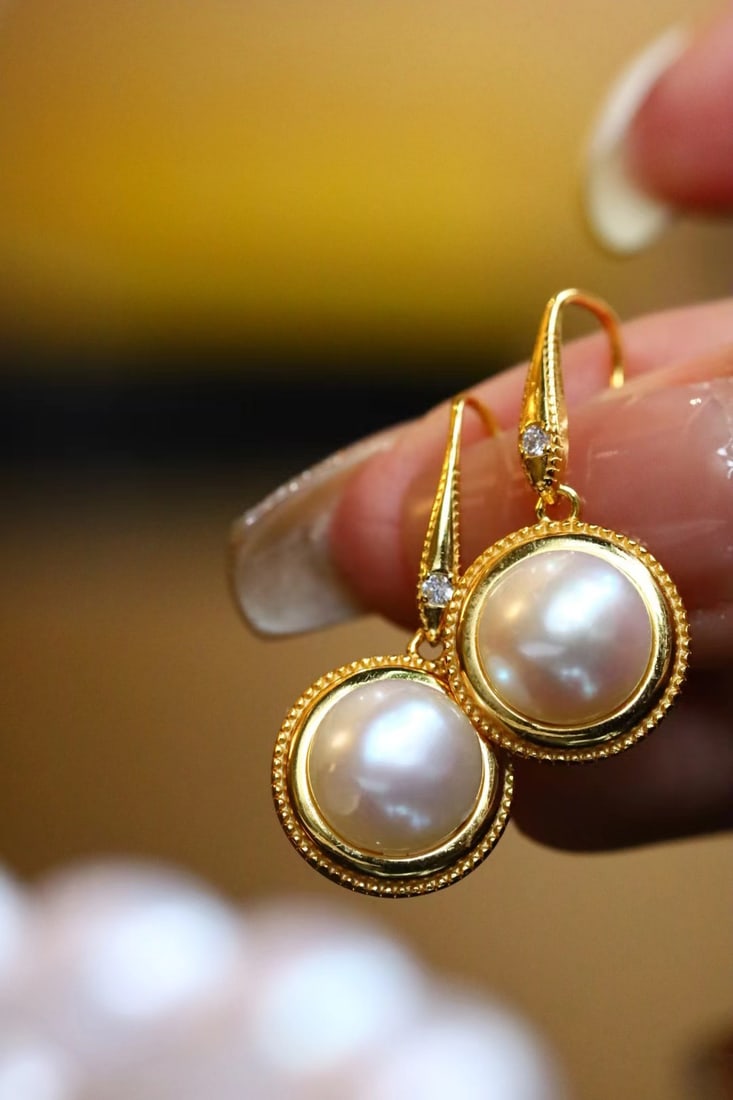 Silver-Plated Natural Freshwater Pearl Earrings: Title: Silver-Plated Natural Freshwater Pearl Earrings Description: These earrings feature natural freshwater pearls with a rich golden and cool white luster. The pearls are large in diameter, nearly