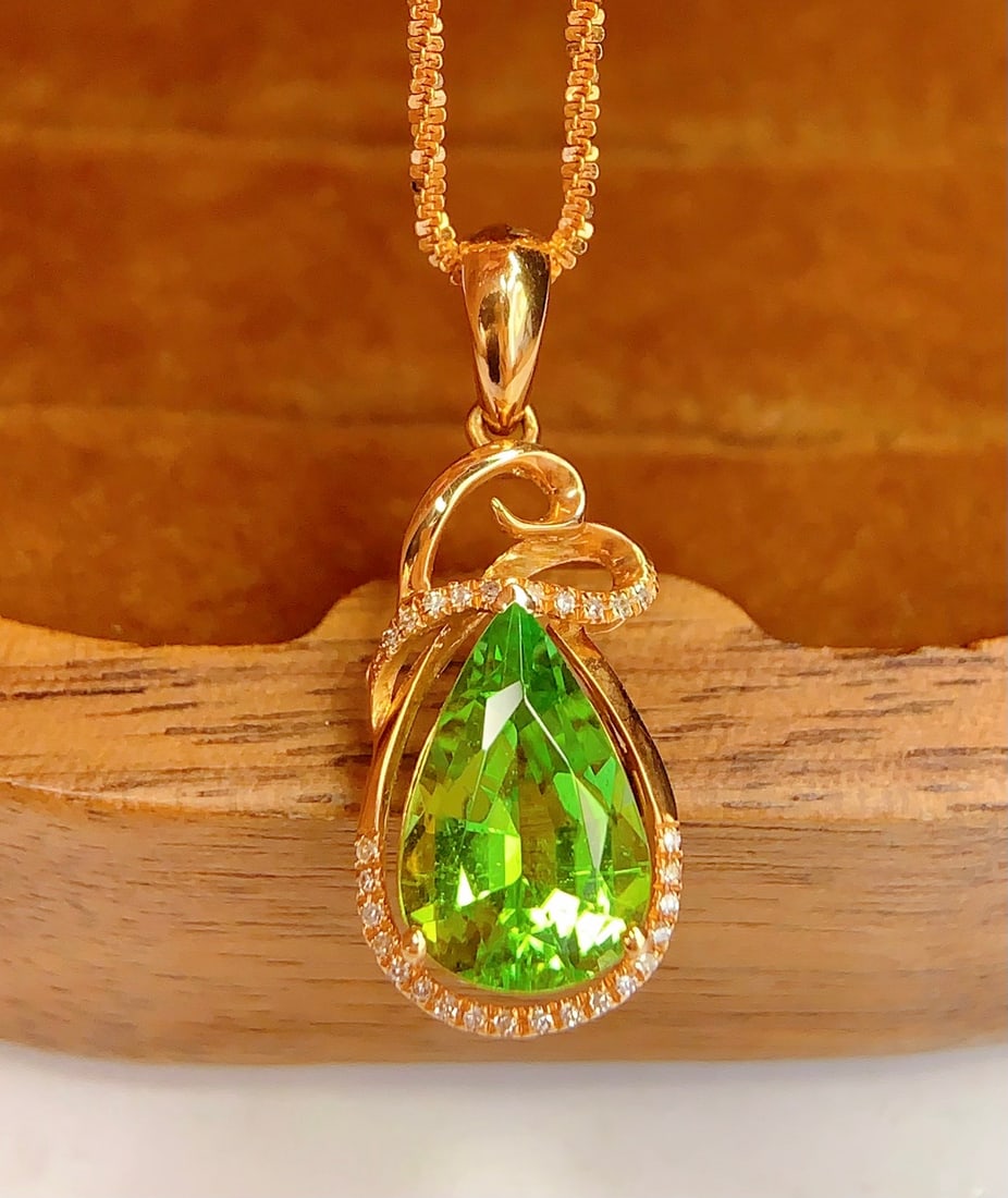 18K Gold Natural Tourmaline Pendant: Title: 18K Gold Natural Tourmaline Pendant Description: This pendant features a natural tourmaline as the main stone, exuding a luxurious deep gold texture with a cool white sheen. The large diameter