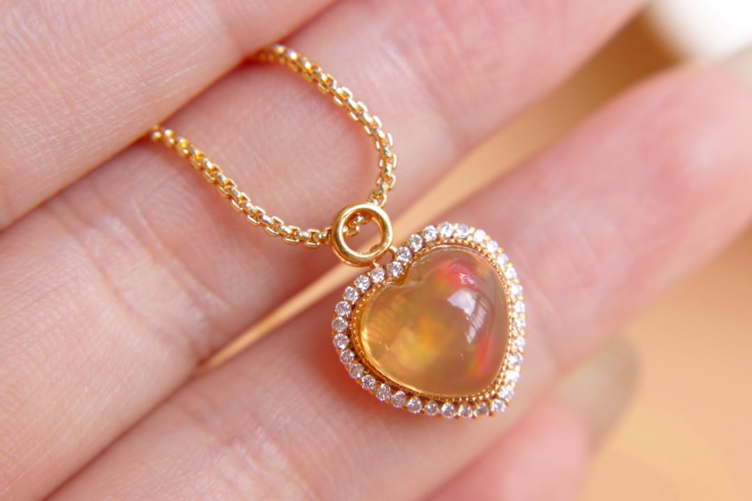 18K Gold Natural Opal Diamond Pendant: Title: 18K Gold Natural Opal Diamond Pendant Description: This pendant features a meticulously set 18K gold with a 2.9-carat natural opal as the centerpiece, showcasing vibrant colors. The rich gold s