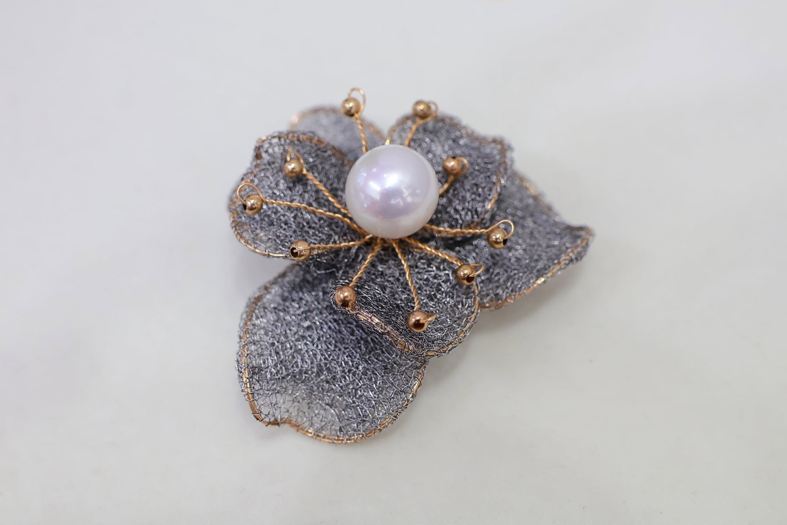 Natural Freshwater Pearl Lace Brooch: Title: Natural Freshwater Pearl Lace Brooch Description: This lace brooch features a natural freshwater pearl with a diameter of 11-12mm, showcasing a blend of rich golden and cool white luster. The