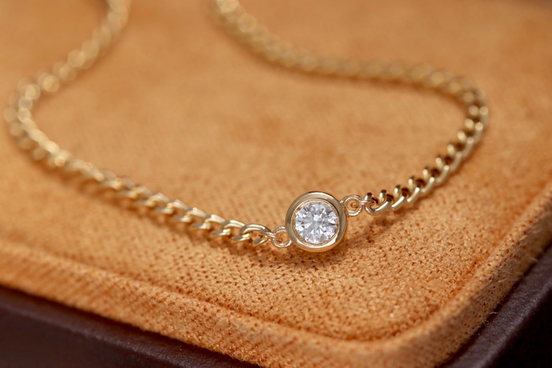 18K Gold Diamond Bracelet: Title: 18K Gold Diamond Bracelet Description: This bracelet is crafted in 18K gold, featuring a textured Cuban chain and diamond embellishments, embodying a design that is simple yet sophisticated.