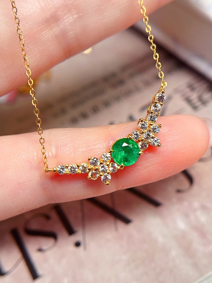 18K Gold Emerald Necklace: Title: 18K Gold Emerald Necklace Description: This necklace is crafted in 18K gold, featuring a natural emerald with a bright and dazzling hue. The main stone is approximately 0.5 carats, complemented