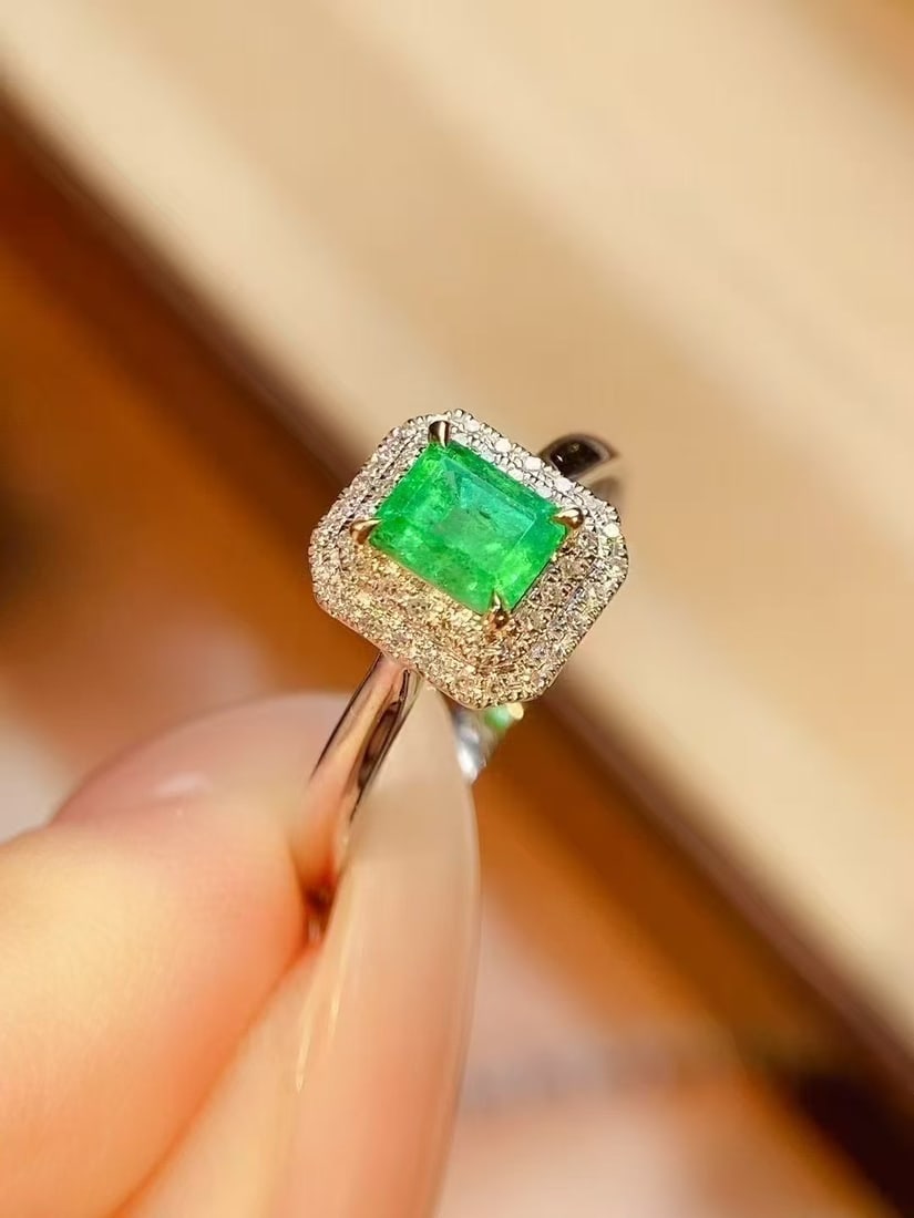 18K Gold Emerald Ring: Title: 18K Gold Emerald Ring Description: This ring is crafted from 18K gold and features a natural emerald as its center stone, weighing 0.56 carats and radiating a rich golden luster with a cool whi